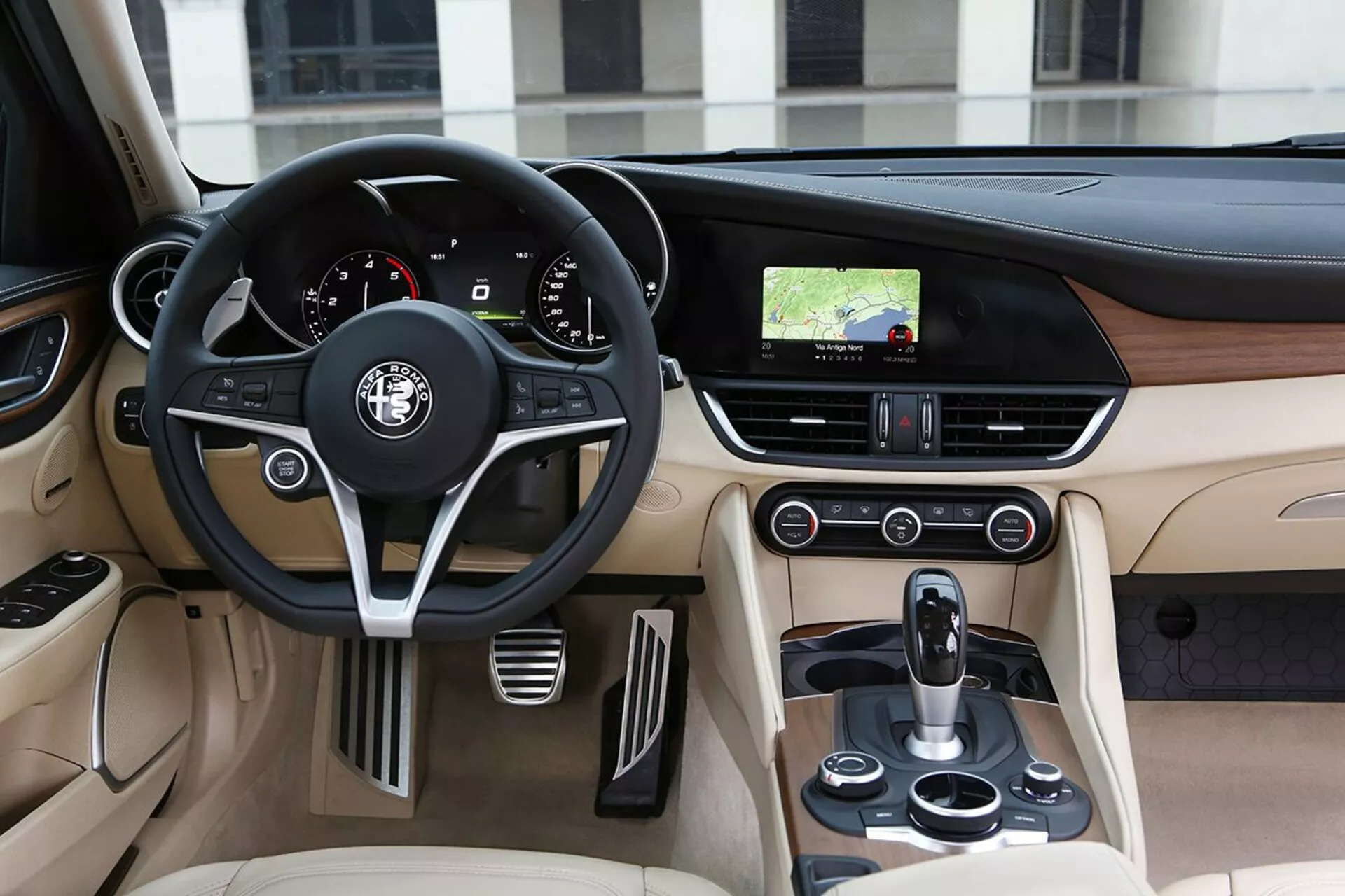 Vista interior de Alfa Romeo Giulia 2016 mostrando el lado del conductor con volante de cuero, tablero y consola central