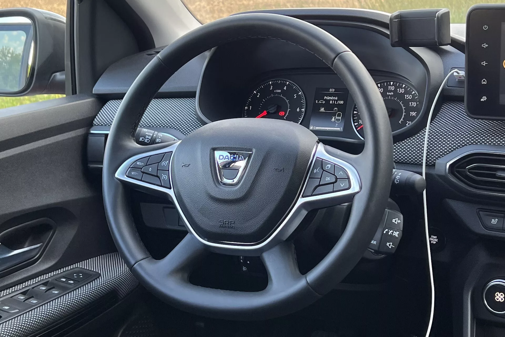 Vista interior del Dacia Jogger 2022 desde el asiento del conductor, enfocando el volante con controles multifunción y el tablero con sistema de infoentretenimiento
