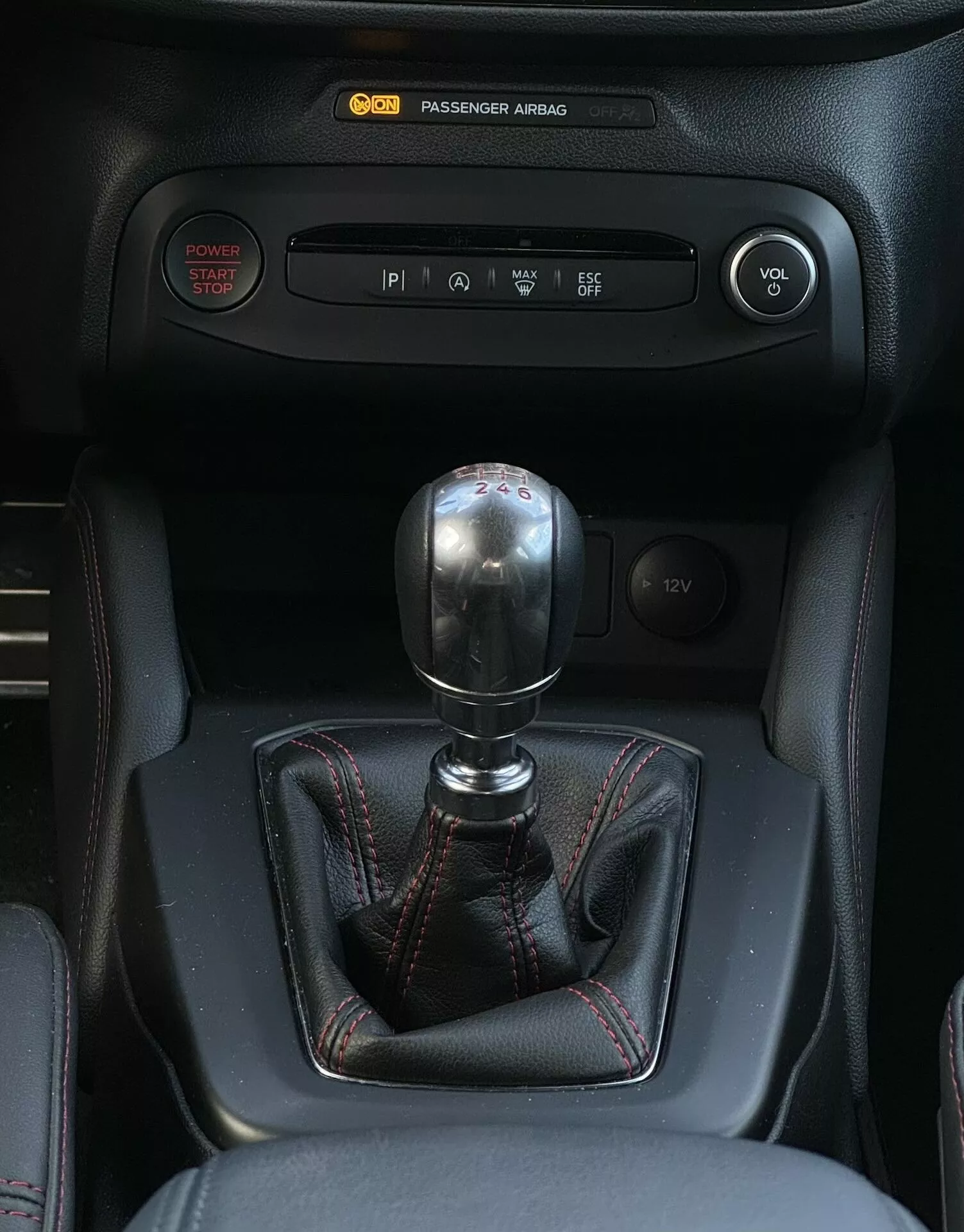 Vista detallada del interior del Ford Focus ST 2022 mostrando el cambio de marchas manual con disposición de 6 velocidades, botón de arranque sin llave, control de clima y controles de infoentretenimiento.