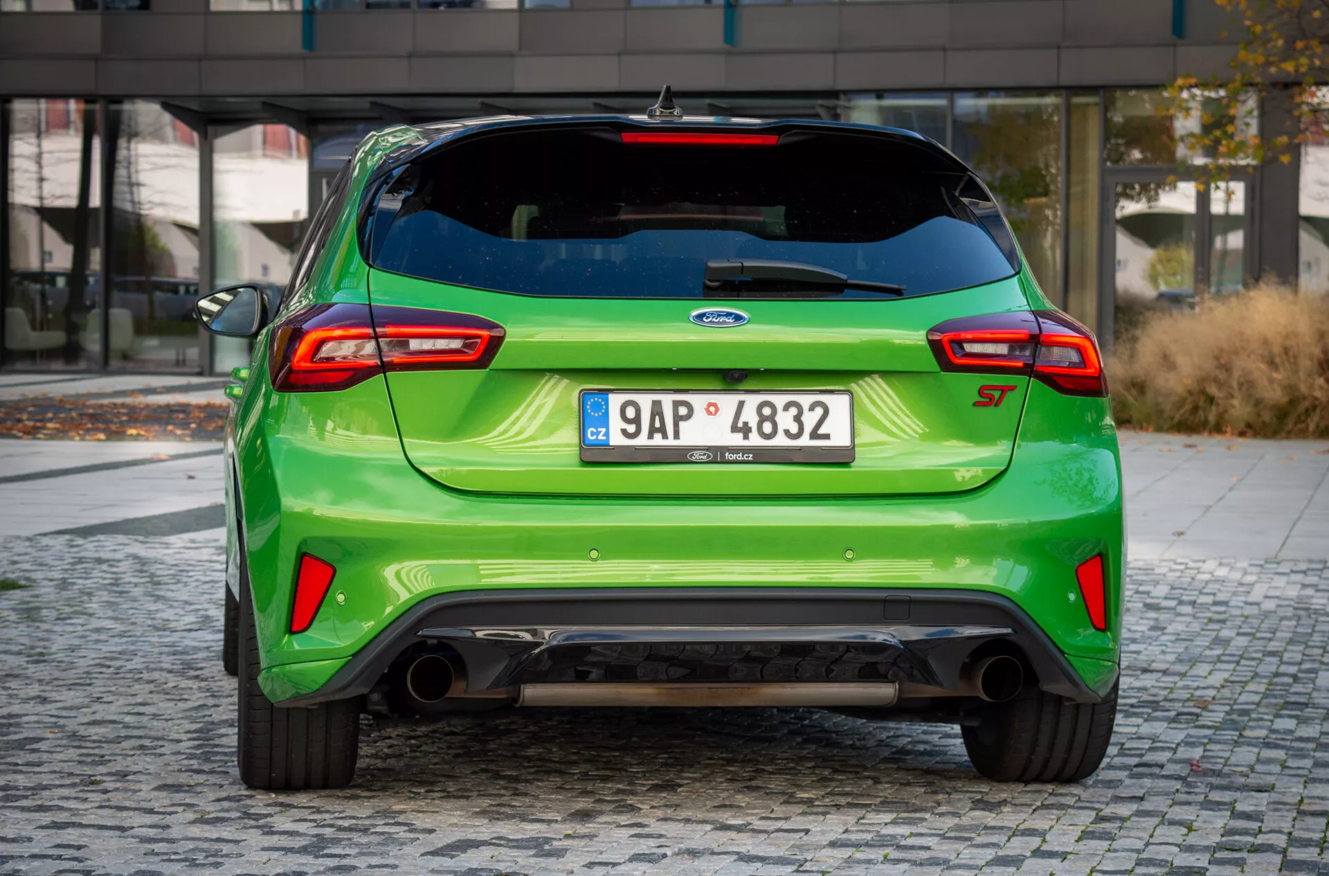 Vista en ángulo trasero del Ford Focus ST 2022, destacando el color verde vibrante, escape deportivo, alerón aerodinámico y luces traseras modernas