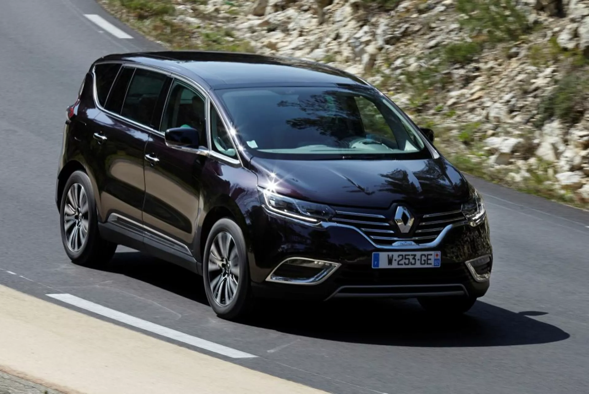 Monovolumen Renault Espace 2015 en movimiento sobre carretera pavimentada, vista frontal tres cuartos que muestra faros LED, ruedas de aleación y características de diseño moderno