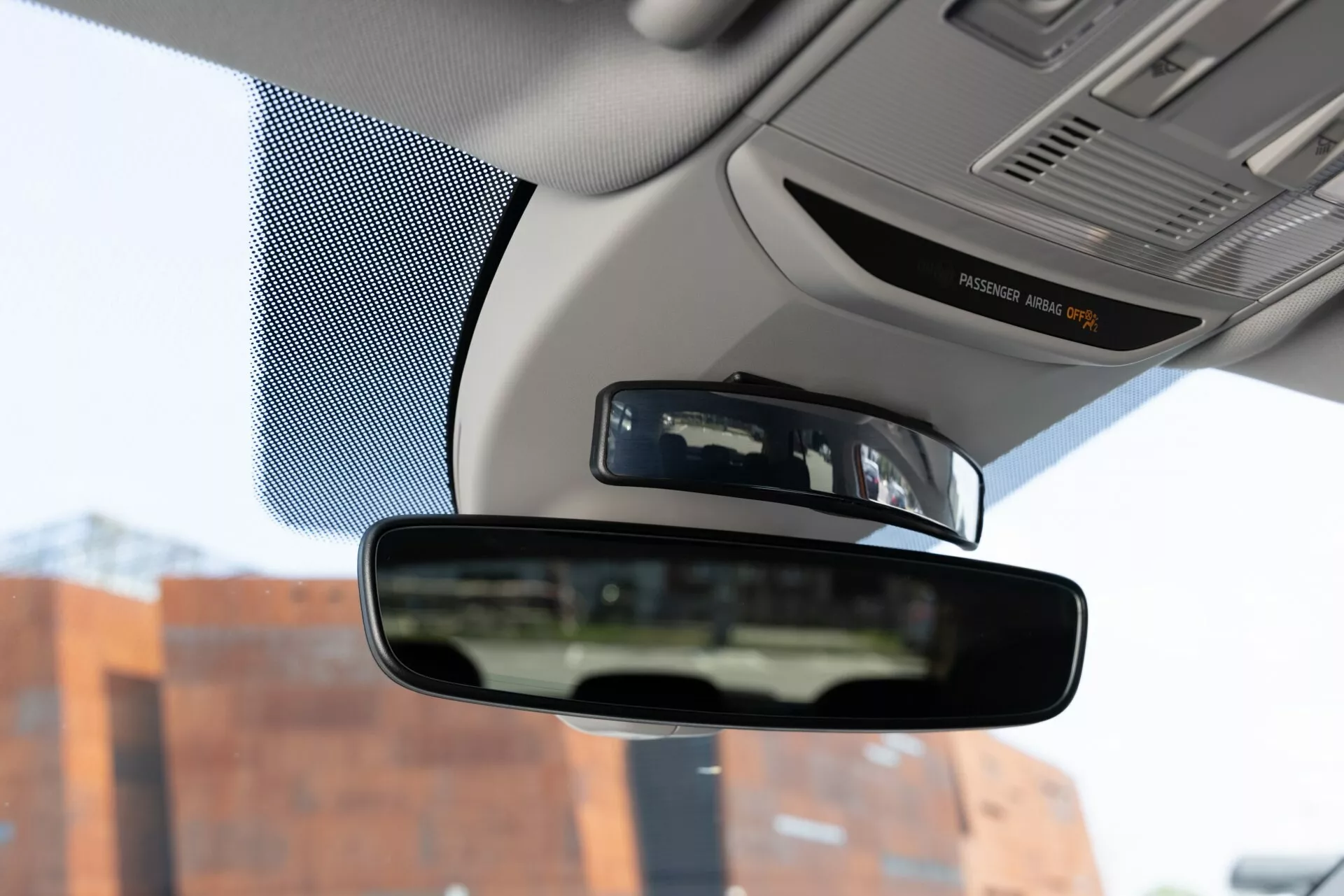 Vista interior del Skoda Fabia 2021, enfocándose en el espejo retrovisor desde la perspectiva del asiento del conductor, capturando el espejo, partes del tablero y los bordes del parabrisas.