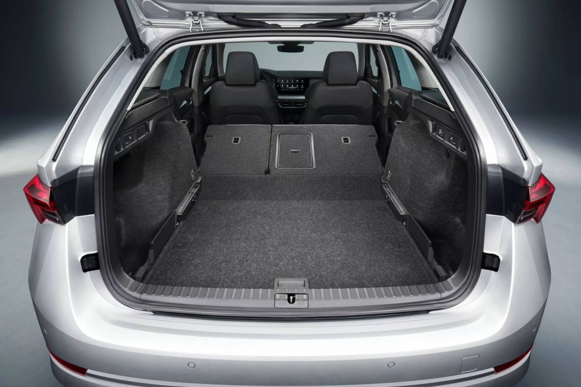 Maletero abierto del hatchback Skoda Octavia 2017 mostrando amplio espacio de carga con asientos traseros abatidos, piso plano, revestimiento de alfombra, puntos de anclaje para almacenamiento seguro, y posibles características tecnológicas avanzadas como luces LED