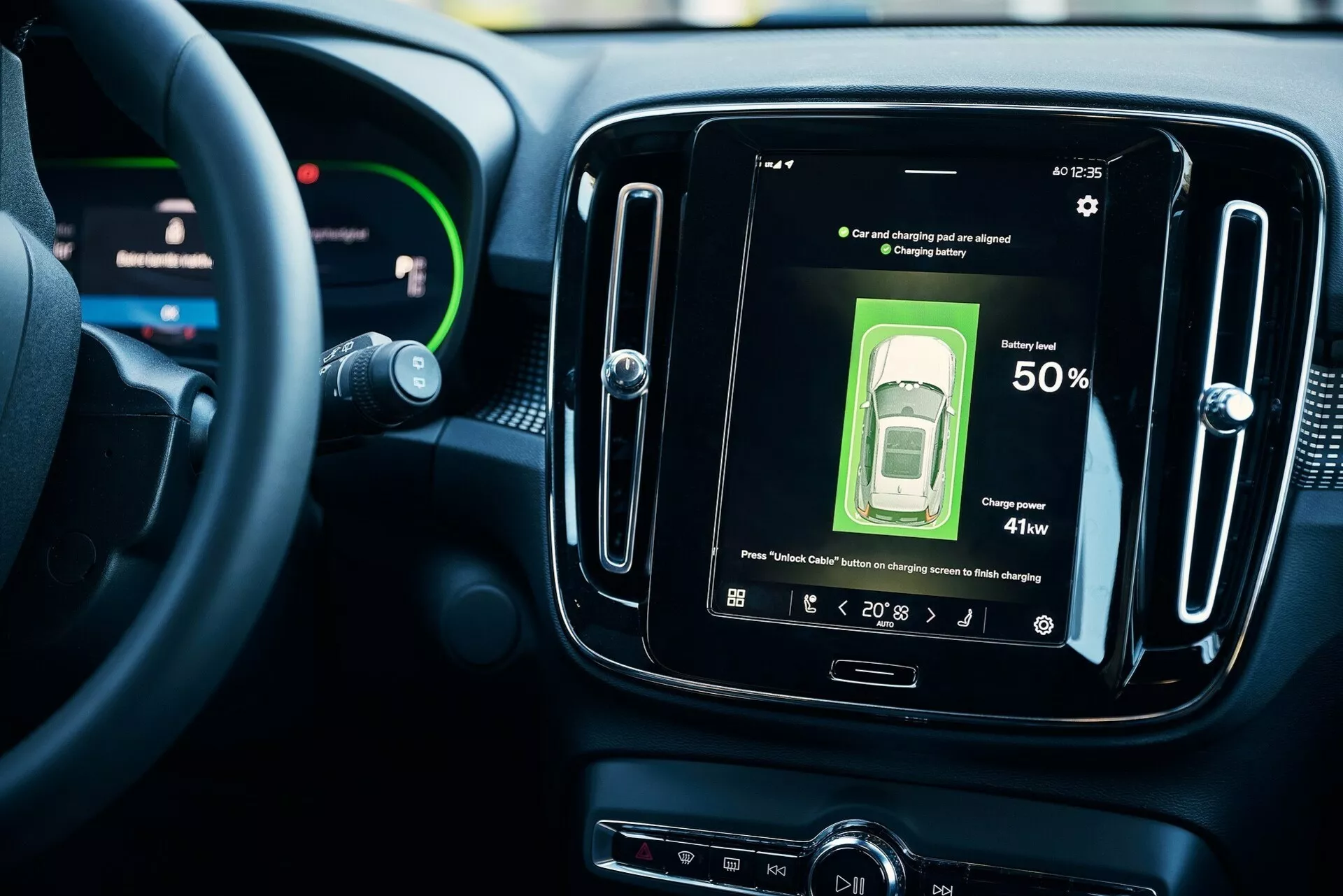 Vista interior de un vehículo moderno, enfocada en el sistema de infoentretenimiento central. Volante parcialmente visible con panel de instrumentos digital y pantalla táctil central que muestra el estado del automóvil con un nivel de batería del 50% y una potencia de carga de 41kw. Indicadores muestran '88' y '20:13'. La pantalla de alta resolución ejemplifica la tecnología automotriz contemporánea en vehículos eléctricos, con un enfoque en la conectividad y una interfaz fácil de usar. Diseño moderno de salpicadero.