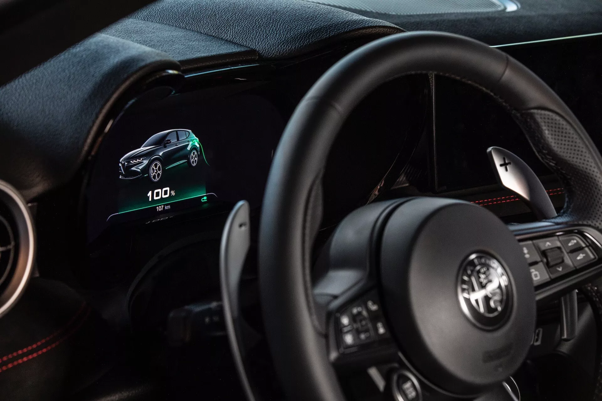 Interior del Alfa Romeo Tonale 2022 mostrando la perspectiva del conductor con tablero digital, volante multifunción e indicadores de vehículo eléctrico