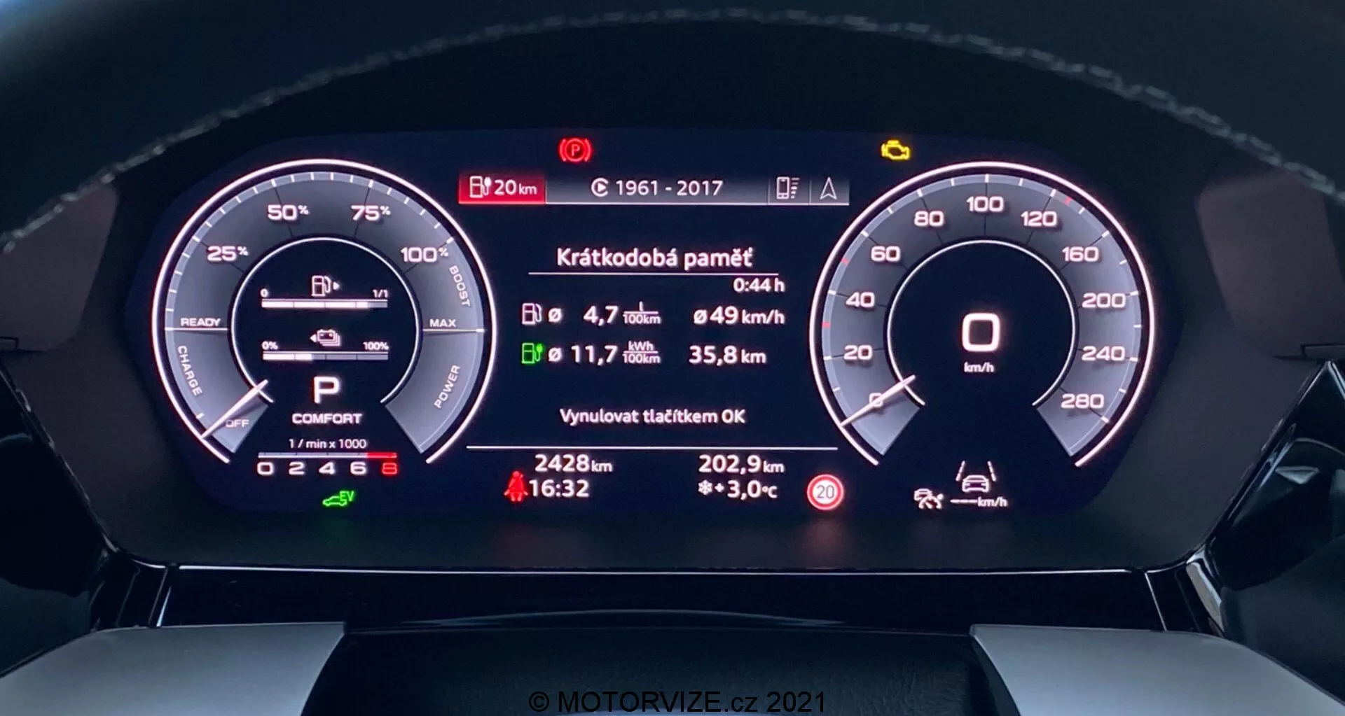 Vista en primer plano del cuadro de instrumentos digital del Audi A3 2020 Sportback, visto desde el asiento del conductor. La perspectiva frontal muestra pantallas digitales detalladas de un tacómetro, indicador de batería, selección de marcha, modo de conducción, velocidad media, consumo de combustible, distancia hasta el tanque vacío, temperatura exterior y un mensaje de estado sobre el mantenimiento reciente. El diseño moderno integra elementos digitales y analógicos para una experiencia tecnológica e intuitiva.