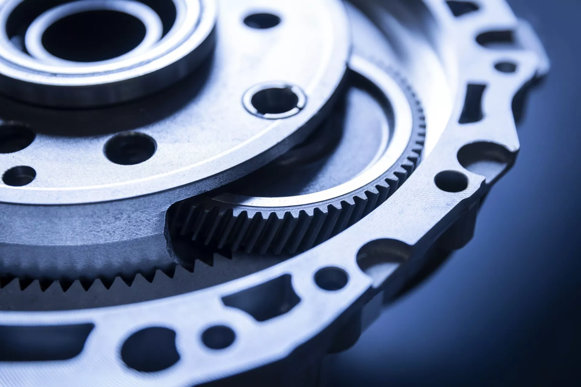 Primer plano de engranaje y rueda dentada de ingeniería de precisión, probablemente para uso automotriz, mostrando un mecanizado fino y potencial para la transmisión de potencia en un entorno industrial fresco