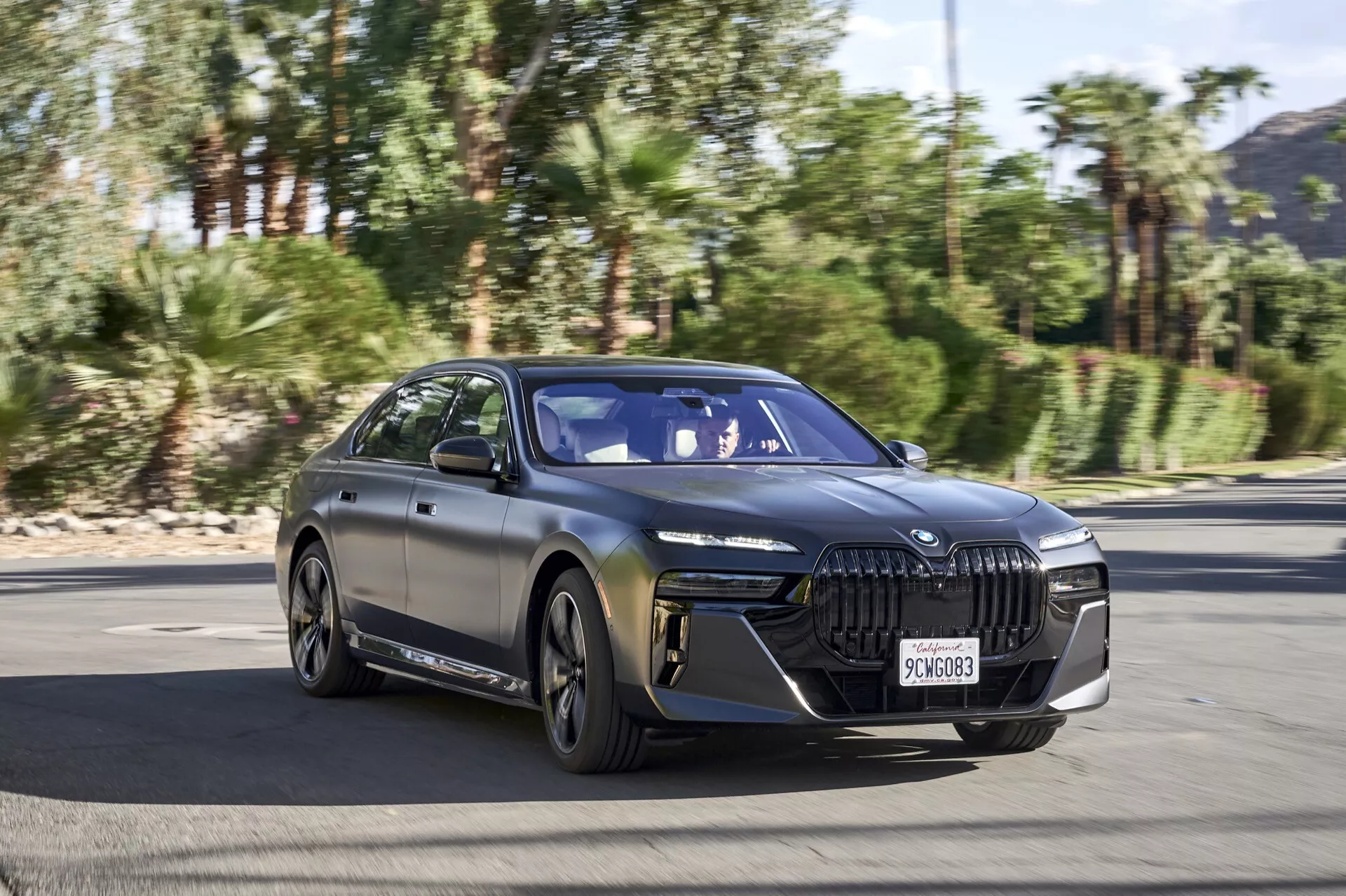 Sedán de lujo eléctrico BMW i7 G70 2022 en movimiento en una autopista, mostrando su diseño elegante y características tecnológicas avanzadas