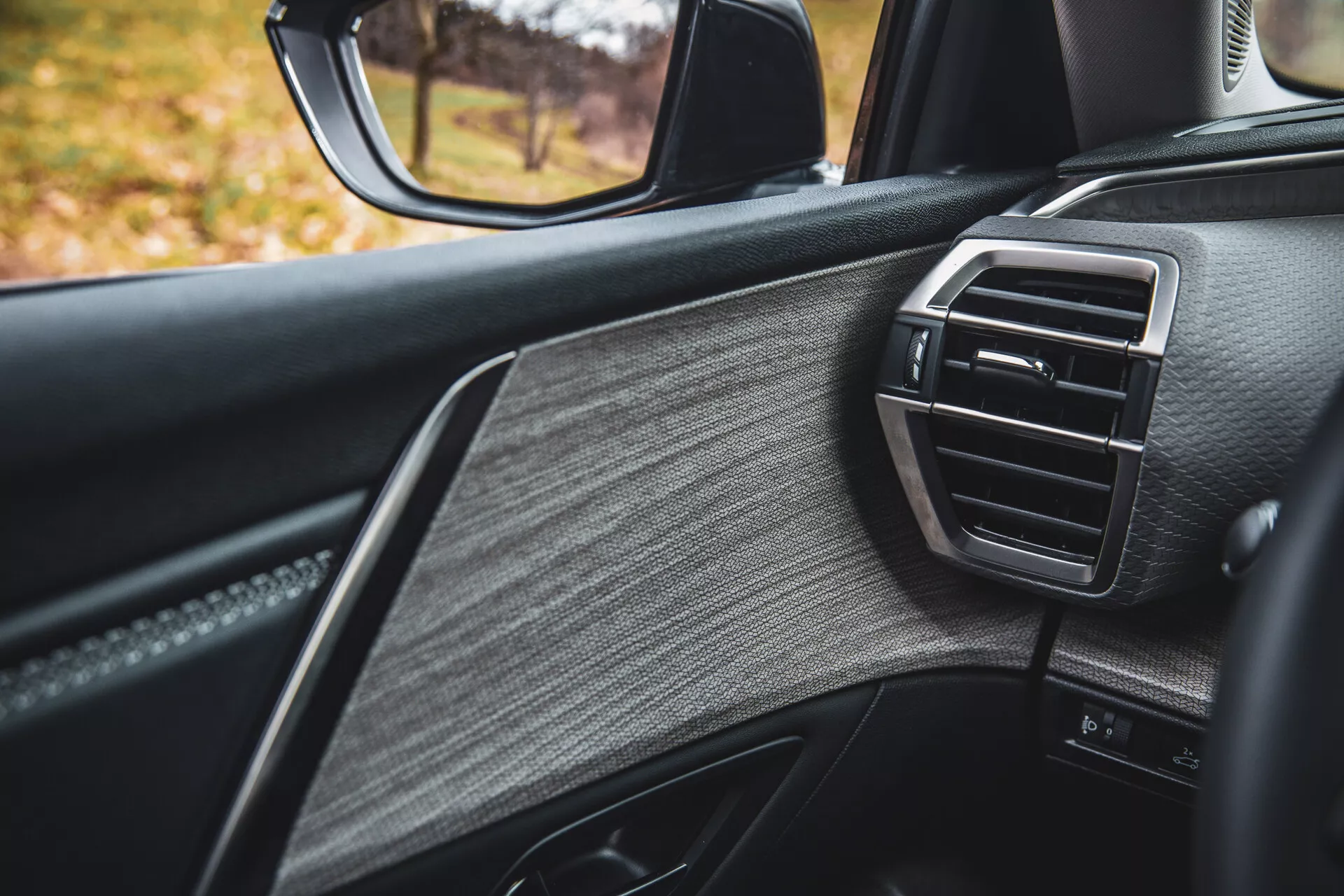 Vista detallada de la puerta del lado del pasajero del Citroen C5-X 2022, mostrando diseño de lujo con cuero texturizado, adornos brillantes y rejilla de ventilación del control climático