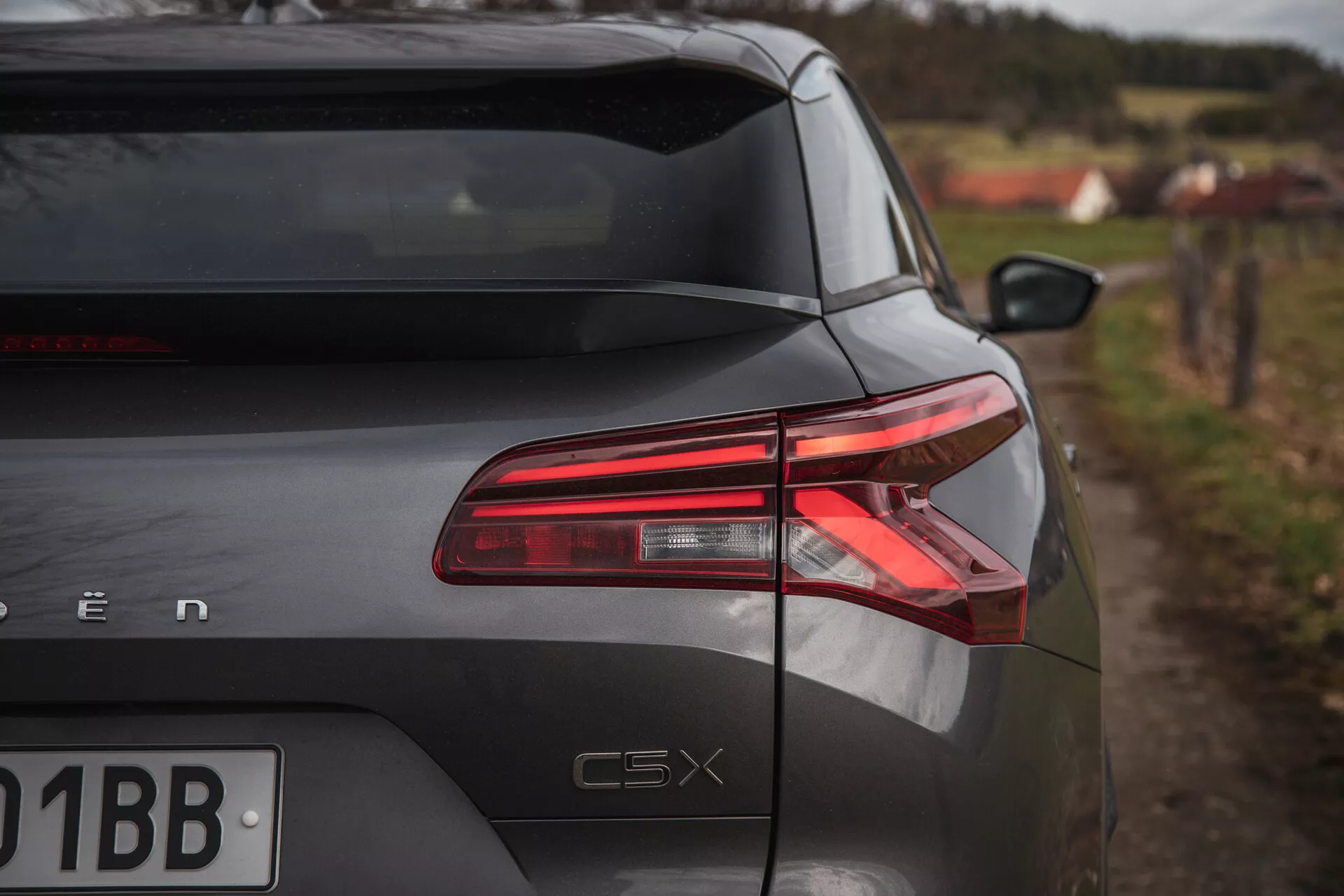 Sección trasera del Citroen C5-X 2022 desde un ángulo oblicuo mostrando luces traseras LED, acabado brillante y distintivo del modelo