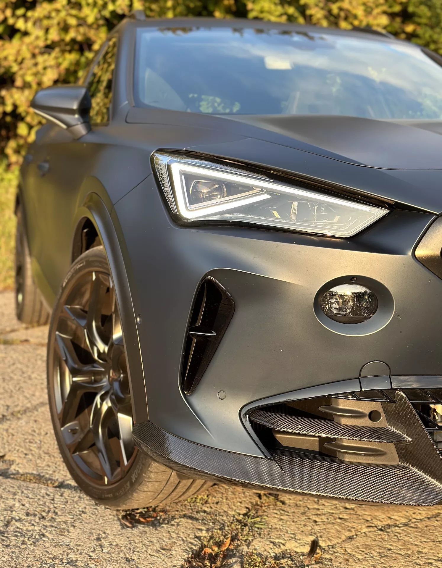 Primer plano del cuarto delantero izquierdo del Cupra Formentor 2020 mostrando faro LED, capó esculpido, parachoques y parrilla orientados al rendimiento y llanta de aleación deportiva