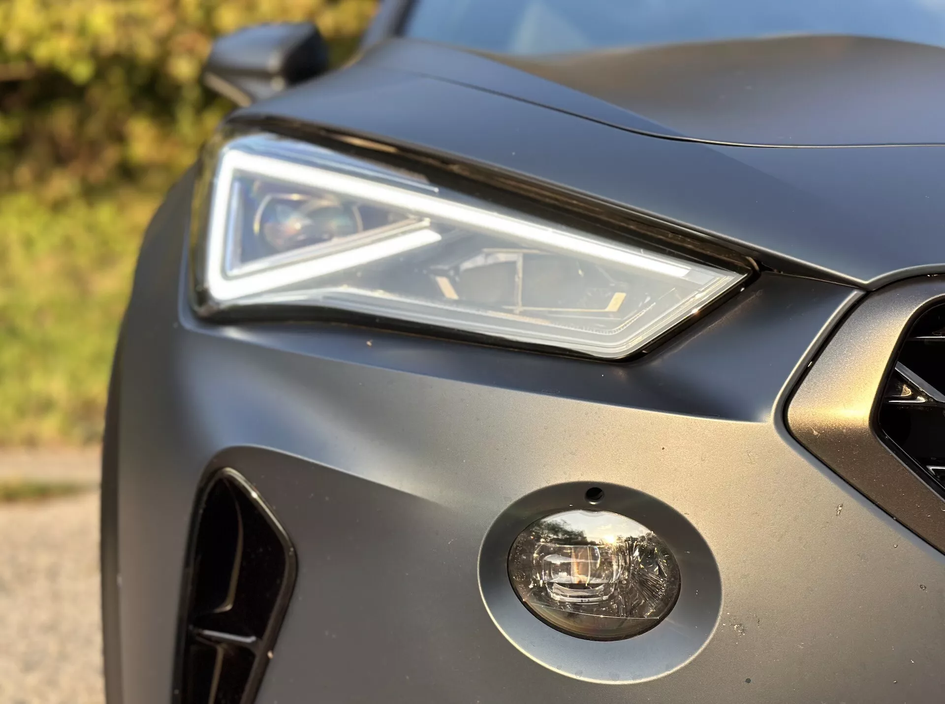 Vista de cerca de la esquina frontal del Cupra Formentor 2020 con conjunto de faro LED, faro antiniebla, parrilla frontal y diseño elegante del panel de carrocería con acabado mate