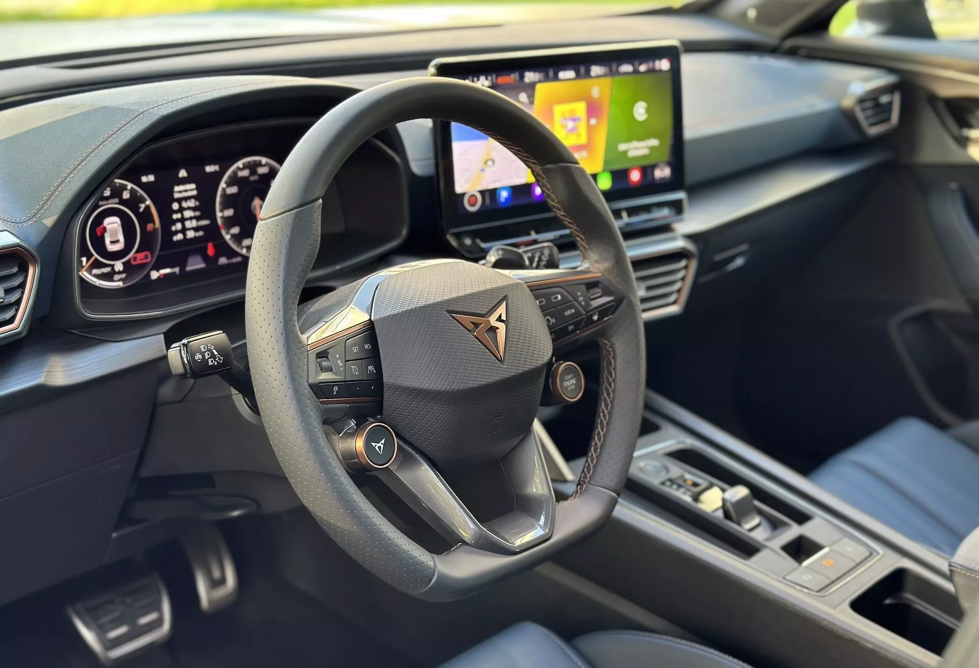 Vista interior del Cupra Formentor 2020 enfocando la perspectiva del conductor con una visión clara del volante multifunción, el tablero digital y parte del sistema de infoentretenimiento, destacado por un diseño moderno y características de tecnología avanzada