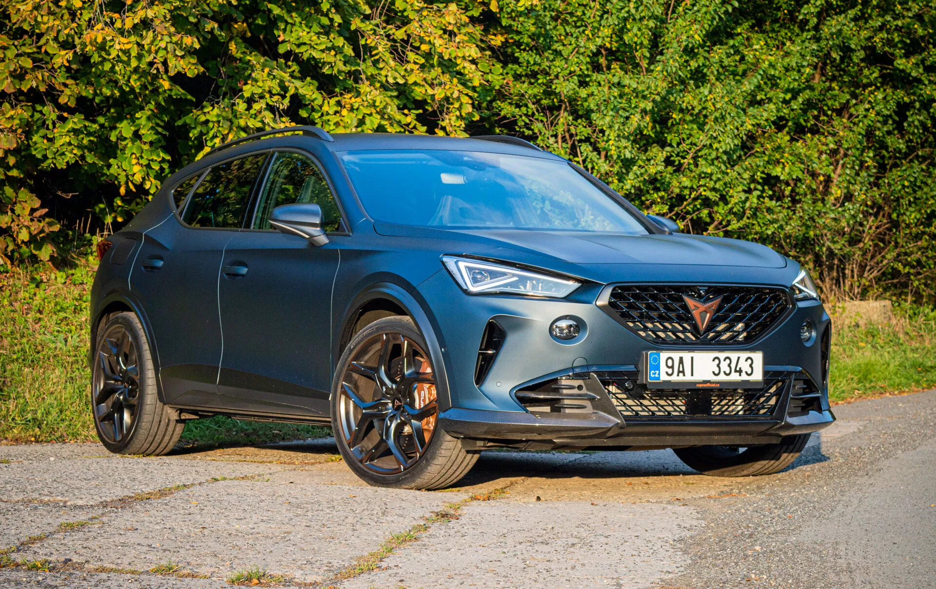 SUV Cupra Formentor 2020 en azul mostrando su parrilla frontal dinámica, faros LED y llantas deportivas de aleación en una vista angulada frontal-lateral, reflejando su diseño moderno y aerodinámico bajo la luz natural del día
