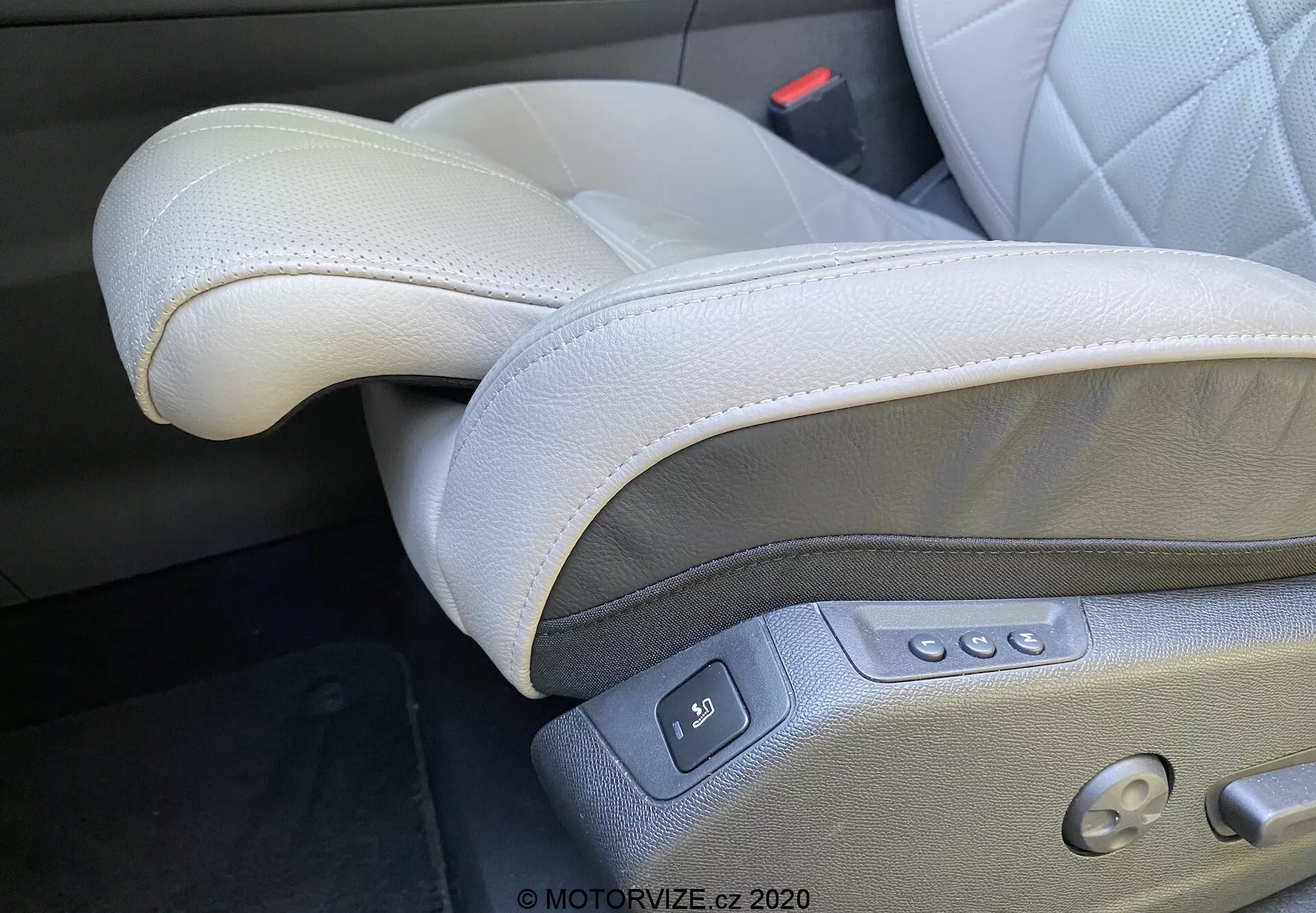 Primer plano del interior del DS Automobiles DS-7 2018 (DS-7 Crossback), enfocándose en el lujoso asiento del conductor de cuero gris claro ubicado en el lado izquierdo en una configuración de conducción por la izquierda. Las características visibles incluyen cuero de alta calidad con costuras, reposacabezas ajustable, controles eléctricos del asiento con múltiples botones para deslizar, reclinar, ajustar la altura y soporte lumbar, así como un botón de ajuste de memoria y un broche de cinturón de seguridad visible, destacando el diseño premium y ergonómico.
