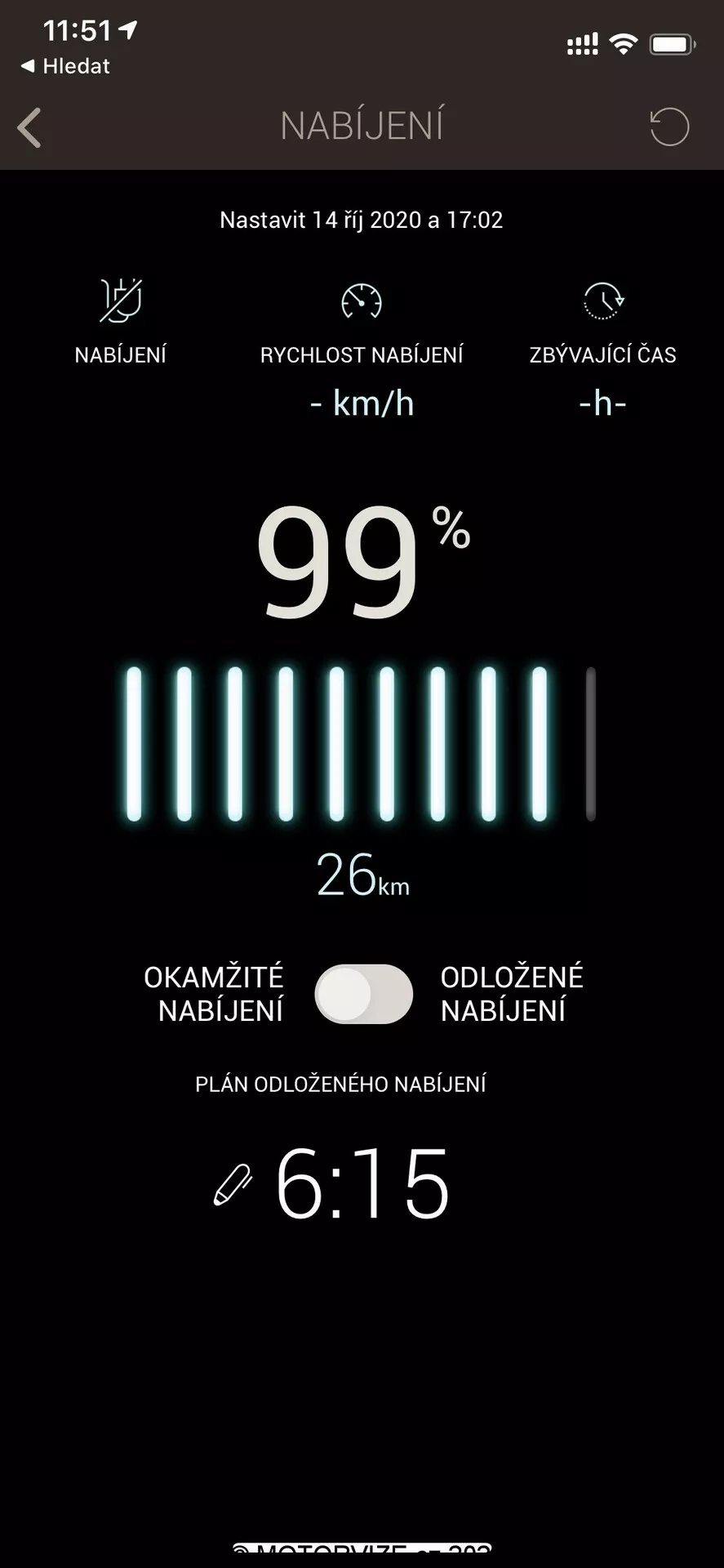 Captura de pantalla que muestra el estado de carga de un vehículo eléctrico en una aplicación móvil o interfaz de sistema de infoentretenimiento. En la parte superior aparece un icono de batería y la palabra 'NABIJENI,' que indica carga en checo. Debajo se muestra una configuración para el 14 de octubre de 2020 a las 17:02 horas. La barra de estado de la batería está casi completamente cargada al 99%, con un indicador de alcance de 26 km. Dos botones etiquetados como 'Carga Inmediata' y 'Carga Demorada' permiten controlar los tiempos de carga. En la parte inferior, un reloj muestra las 6:15 para la carga demorada. La interfaz tiene un diseño limpio con fondo negro y texto en blanco y verde, ideal para mejorar la legibilidad.