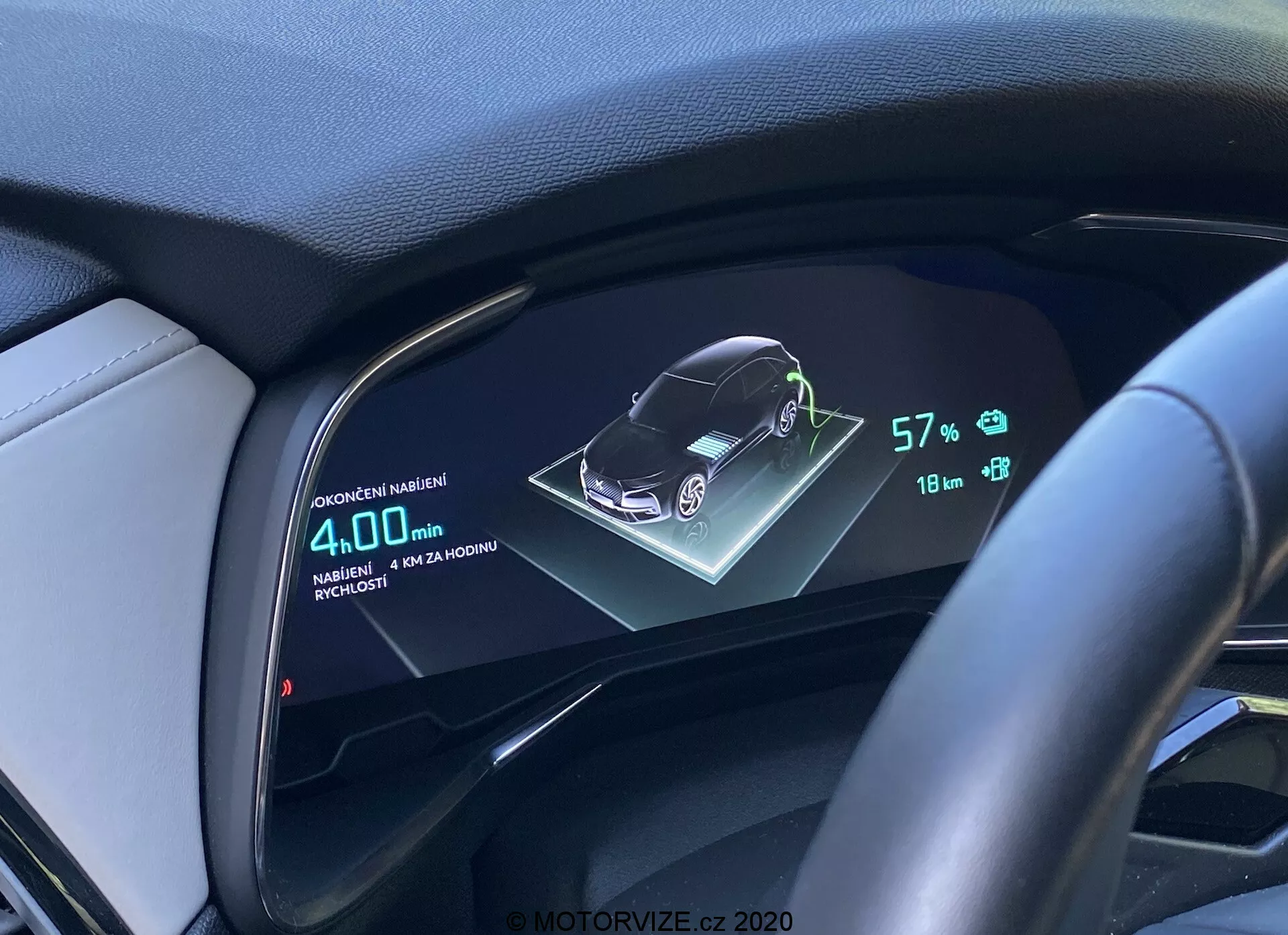 Pantalla digital del tablero de un DS Automobiles DS-7 2018 (DS-7 Crossback) mostrando una representación gráfica 3D del vehículo, estado de la batería al 57%, autonomía de 18 km y consumo promedio de combustible de 4.0L/100km, desde la perspectiva del conductor con volante y tablero acabado en cuero.