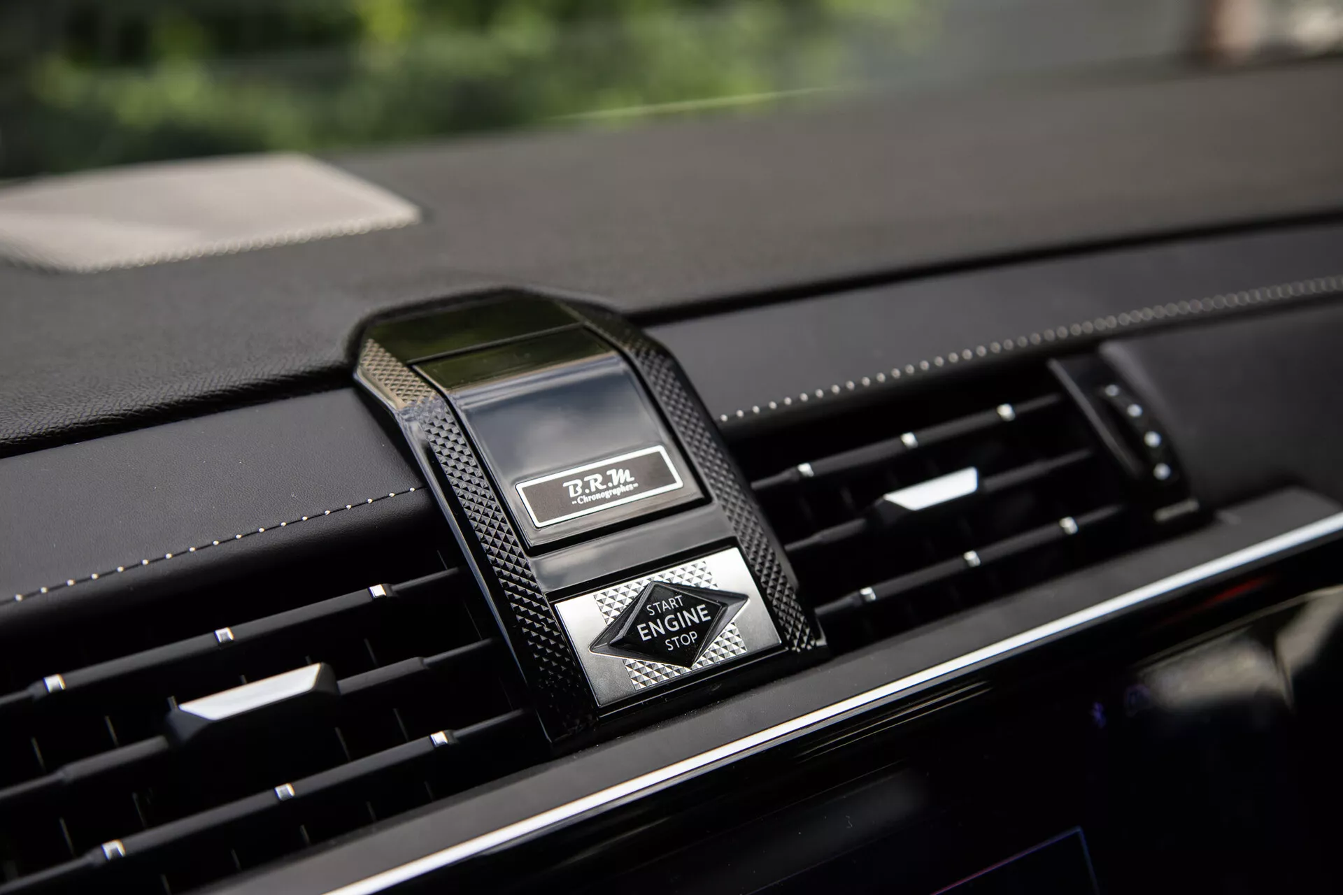 Primer plano del tablero central del DS Automobiles DS-7 2022 con reloj analógico de lujo y salidas de aire, destacando materiales premium y diseño moderno