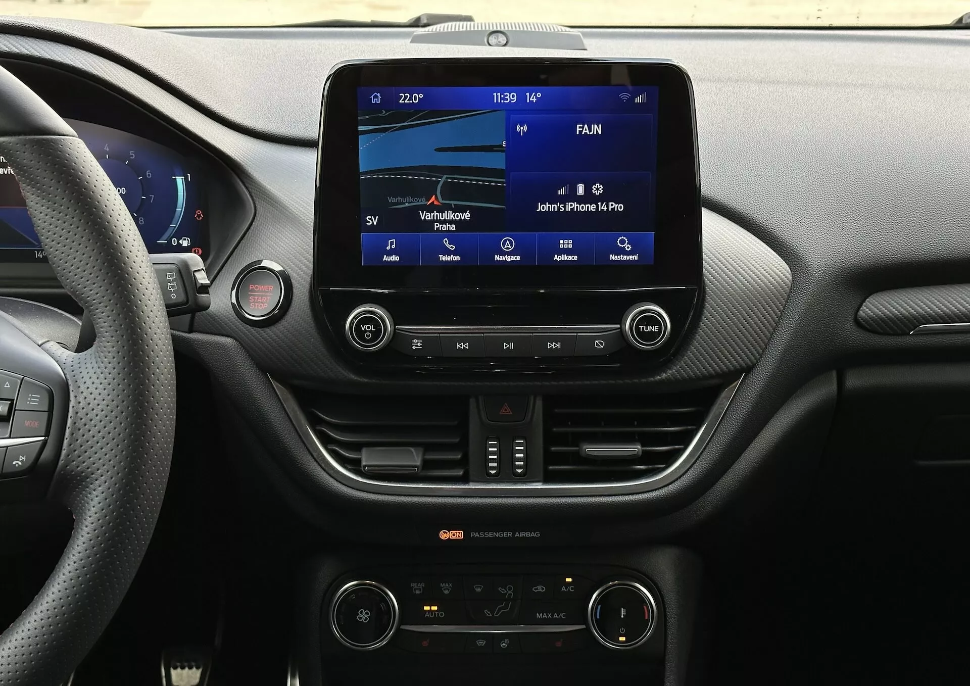 Vista del tablero interior del Ford Fiesta 2022 desde el asiento del conductor enfocándose en el sistema de infoentretenimiento y las características de la consola central, incluyendo pantalla táctil, conectividad Bluetooth y control climático bizona