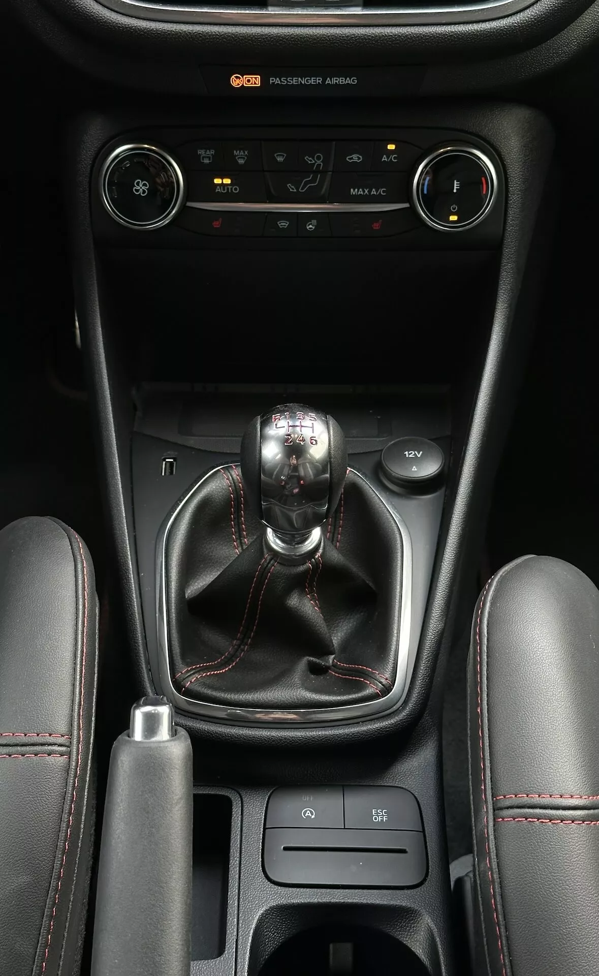 Consola central del Ford Fiesta 2022 con control climático, cambio de marchas manual, selector de modo de conducción y compartimentos de almacenamiento