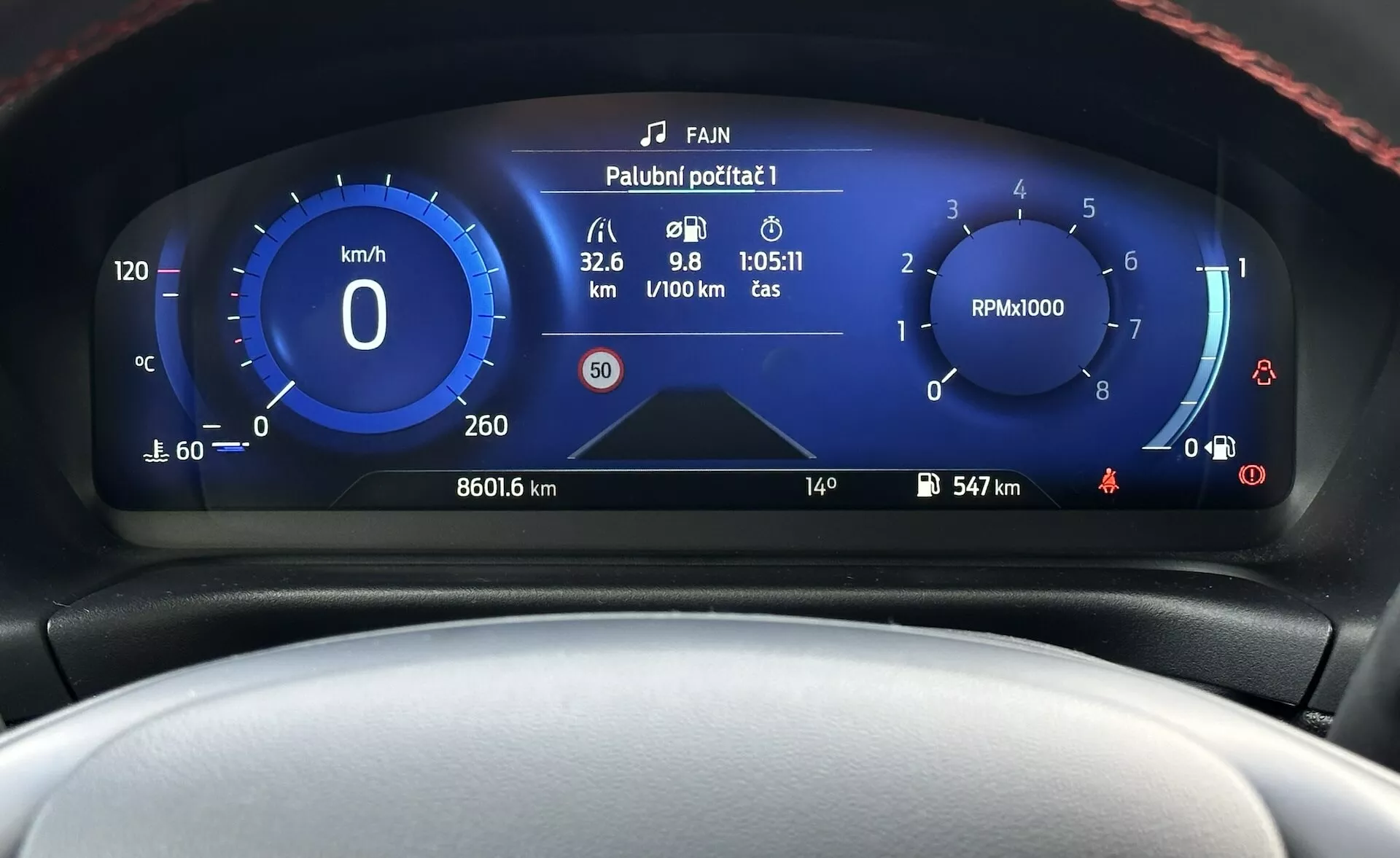 Cuadro de instrumentos digital del Ford Fiesta 2022 mostrando una vista frontal detallada con velocímetro, tacómetro, medidor de eficiencia de combustible y varios indicadores de estado del vehículo en un diseño moderno con esquema de colores azul y blanco.