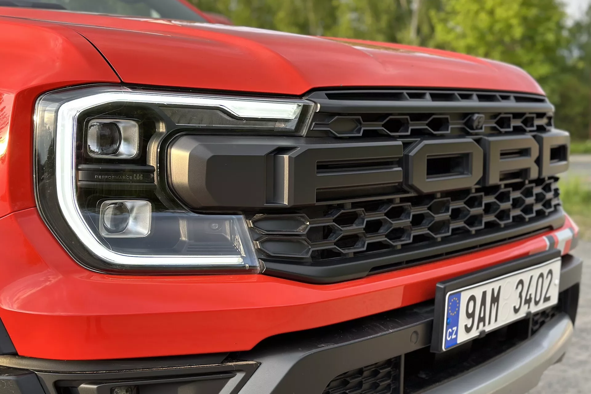 Primer plano del lado frontal izquierdo del Ford Ranger 2022 destacando el diseño de faros LED y el patrón de parrilla de panal, con la inscripción 'FORD'
