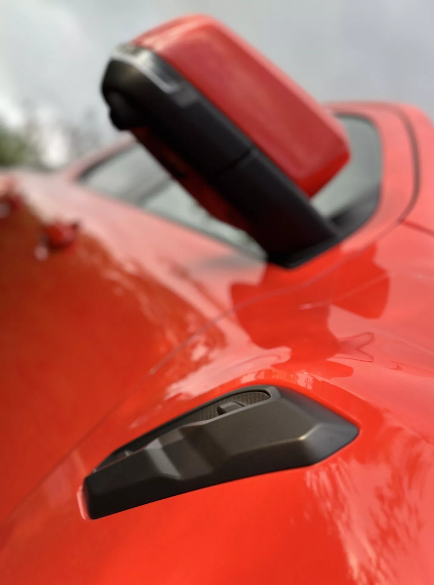 Primer plano del guardabarros trasero y alerón del Ford Ranger 2022 con acabado rojo brillante, que muestra una rejilla negra para mejorar la aerodinámica, enfatizando su diseño deportivo bajo una profundidad de campo superficial