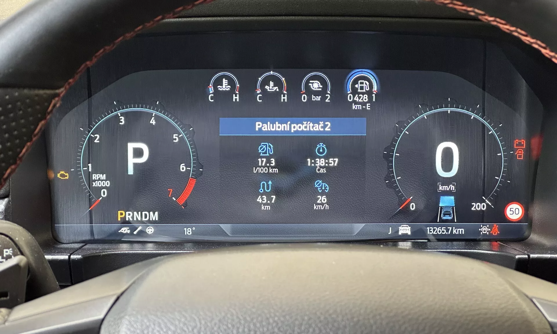 Vista desde el asiento del conductor del cuadro de instrumentos digital del Ford Ranger 2022 que muestra el tacómetro, el indicador de combustible, el velocímetro, la pantalla de temperatura y la selección de marchas en el tablero moderno del vehículo