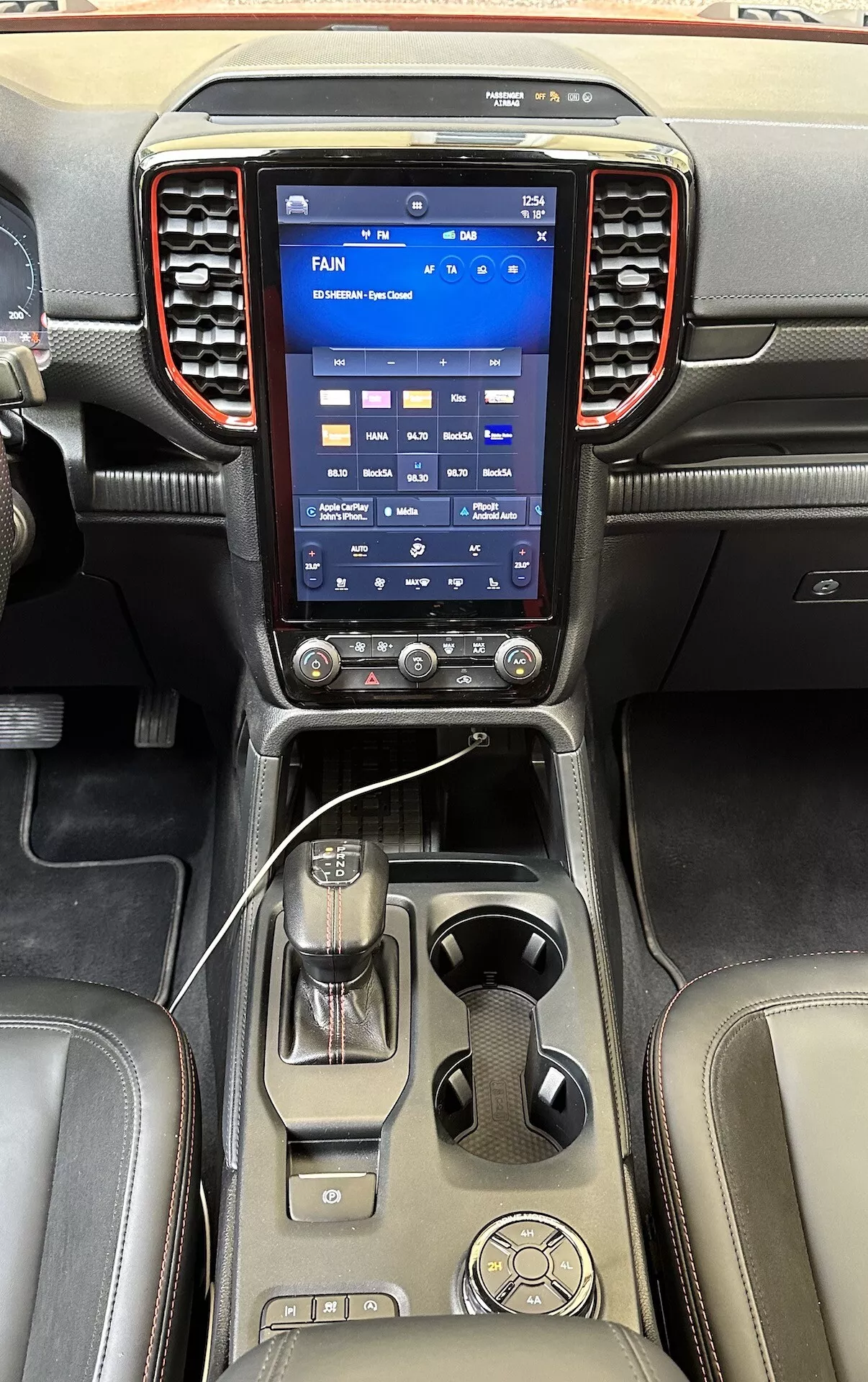 Consola central sofisticada del Ford Ranger 2022 con un gran sistema de infoentretenimiento táctil vertical, perillas de control climático, palanca de cambios y acabados de cuero lujosos