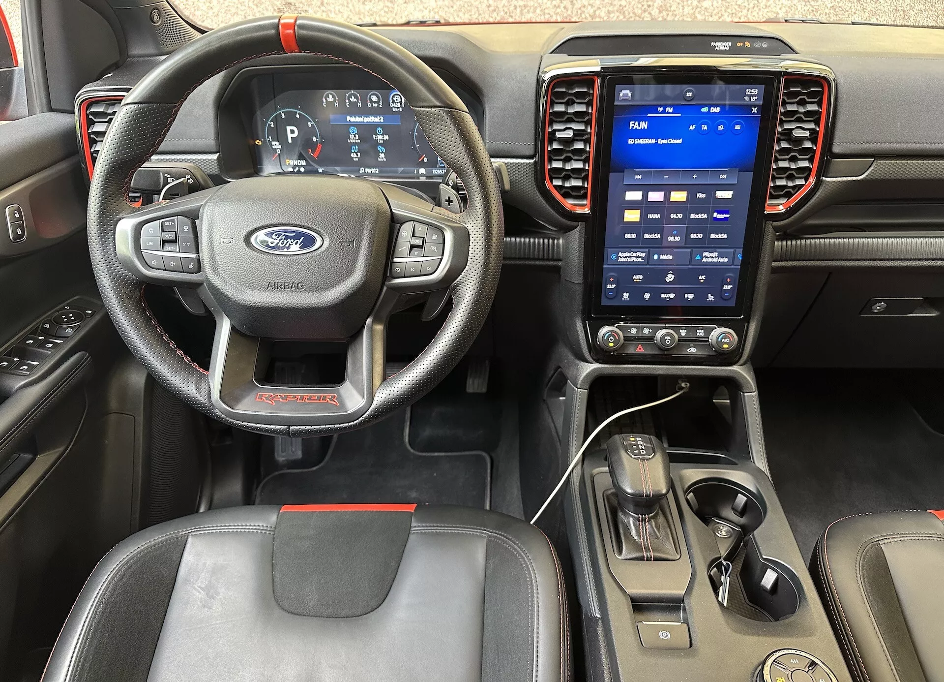 Vista interior de Ford Ranger 2022 mostrando la perspectiva del conductor, con un volante de 3 radios con controles, cuadro de instrumentos digital y sistema de infotenimiento táctil vertical en el tablero