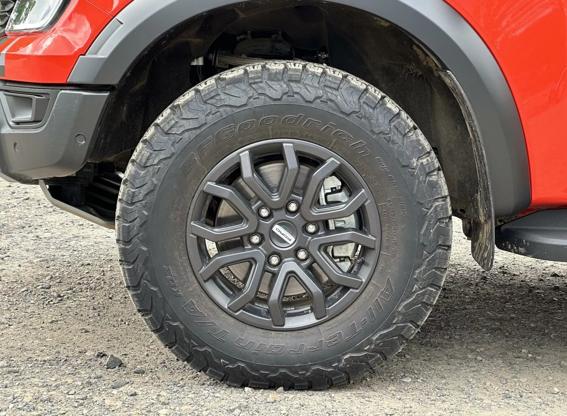 Primer plano de la rueda del Ford Ranger 2022, mostrando diseño de aleación multirradio, dibujo de neumático todoterreno y sección del guardabarros con claridad de suspensión visible