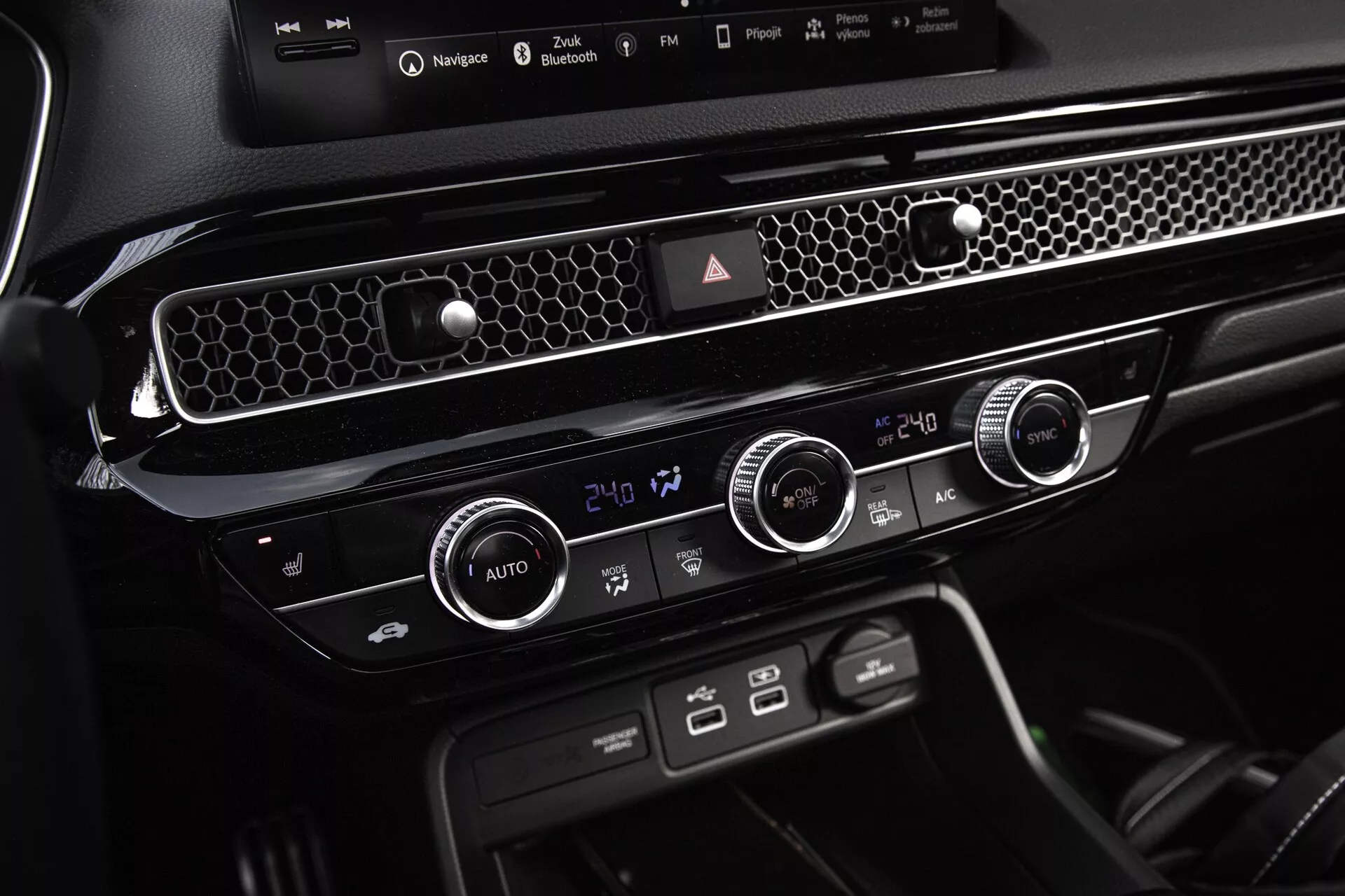 Consola central y unidad de control climático del Honda Civic 2022 que muestra controles de temperatura de doble zona, ventilación con acentos cromados y botones de función dedicados para un diseño interior moderno y simplificado
