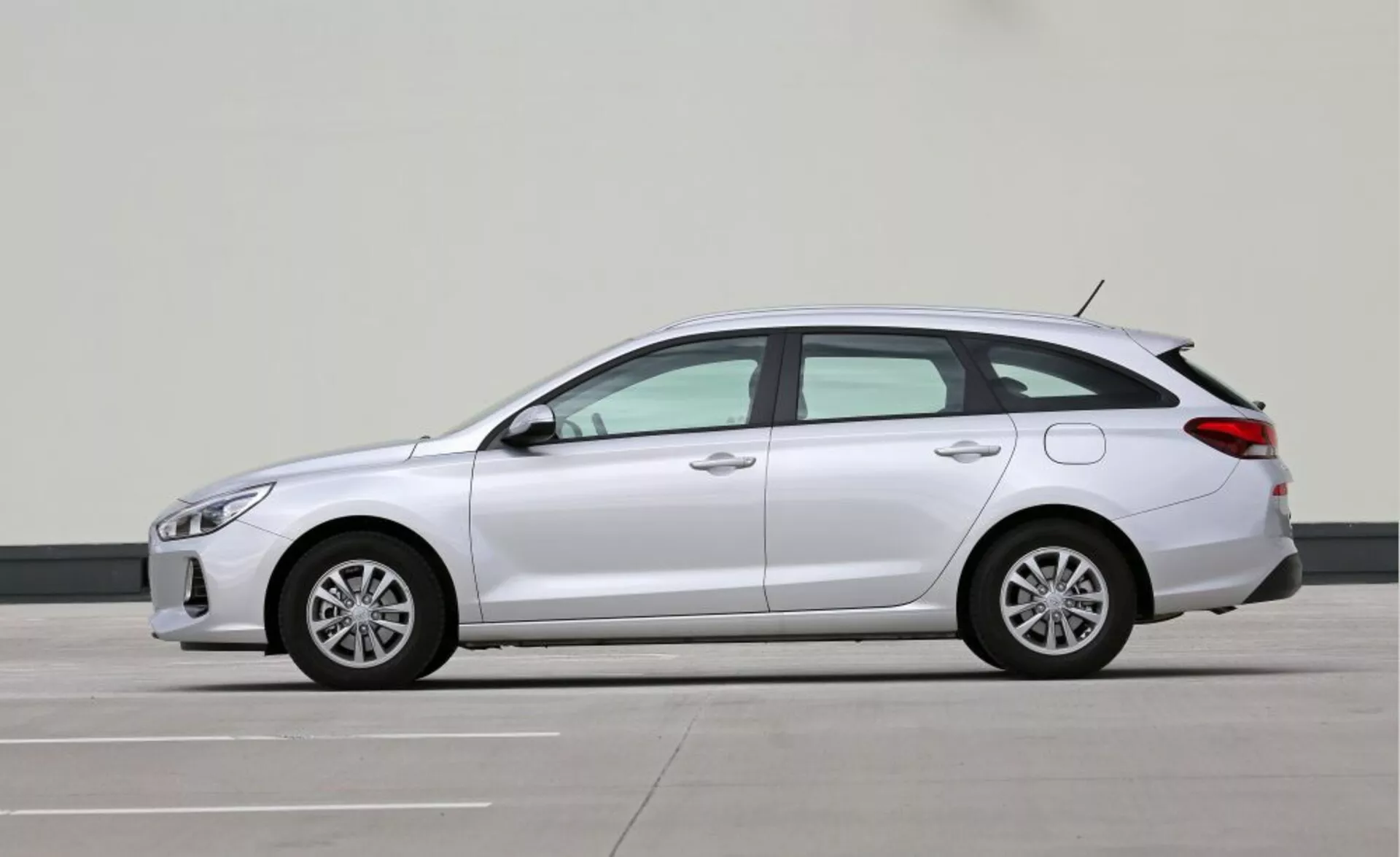 Hyundai i30-N hatchback compacto de 2017 en vista de perfil resaltando sus elegantes faros LED, señales de giro integradas en espejos laterales, líneas aerodinámicas, ruedas de aleación, larga distancia entre ejes para mayor comodidad, y posible tren motriz híbrido o eléctrico indicado por la ausencia de tubos de escape visibles, en un entorno de fotografía profesional