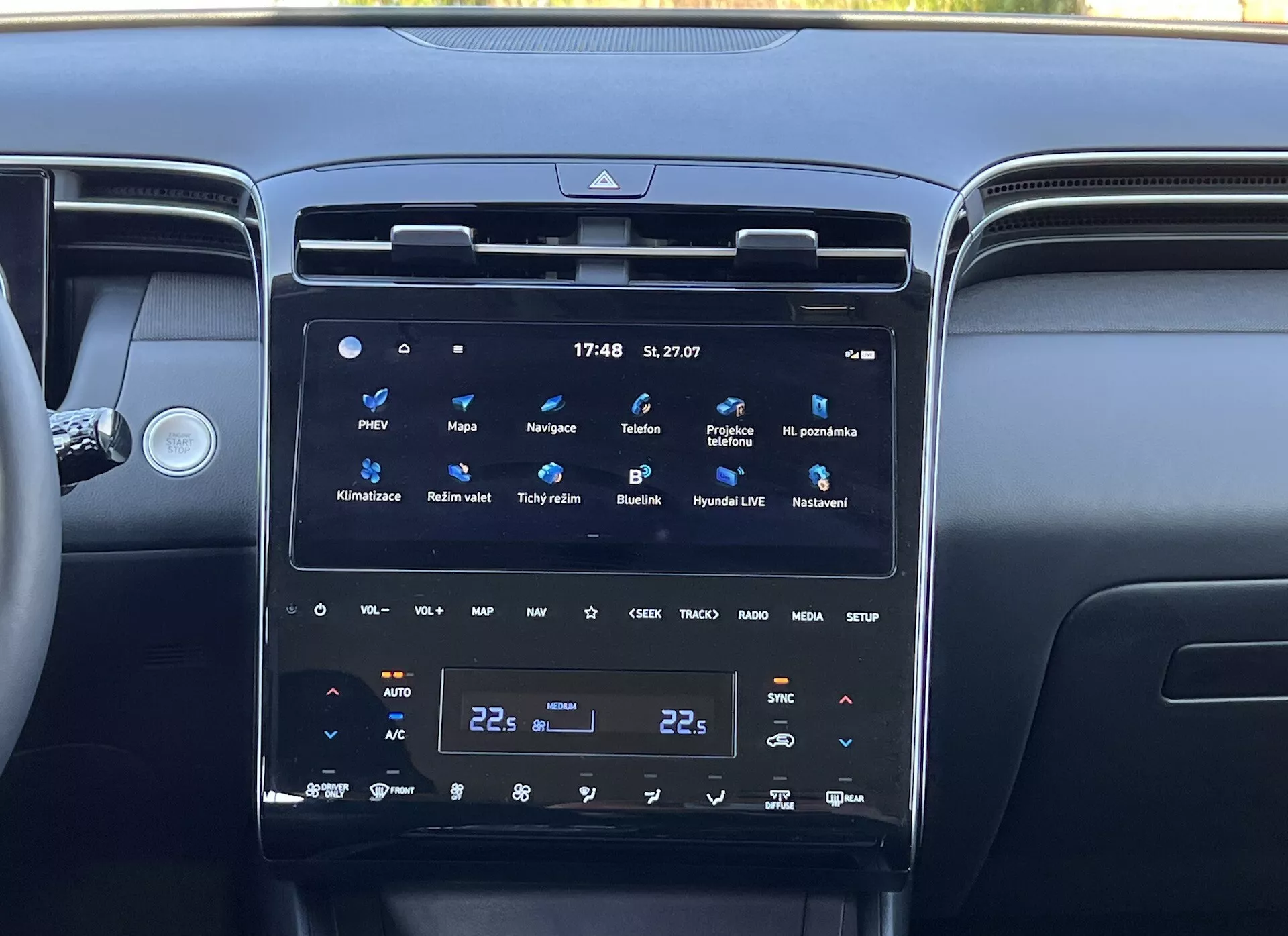 Interior del Hyundai Tucson 2020 mostrando la consola central con una gran pantalla táctil vertical del sistema de infoentretenimiento, control climático de dos zonas y rejillas de ventilación circundantes, reflejando la tecnología moderna del vehículo y el lujo