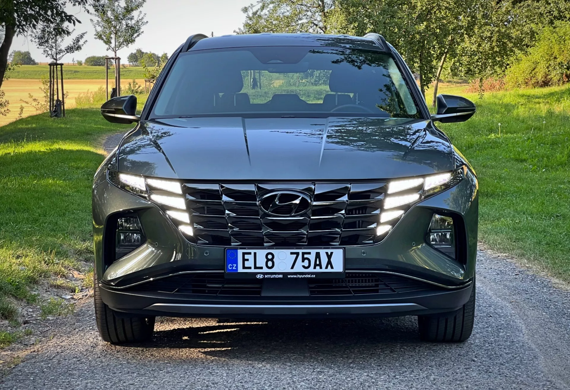 Hyundai Tucson 2020 visto desde un ángulo bajo frontal, mostrando su diseño moderno con líneas angulares, faros LED, parrilla en cascada y sistemas avanzados de asistencia al conductor en un entorno rural a plena luz del día