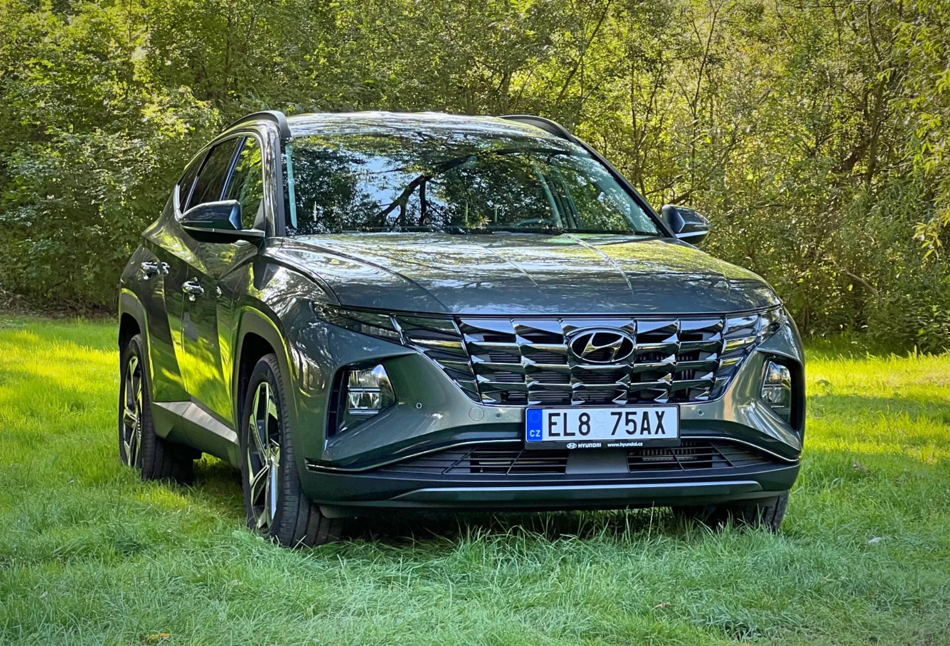 SUV Hyundai Tucson 2020 con acabado metálico, mostrando faros LED, parrilla frontal prominente, diseño de capó esculpido, ruedas de aleación y espejos laterales con señales de giro integradas, estacionado sobre césped resaltando su capacidad todo terreno