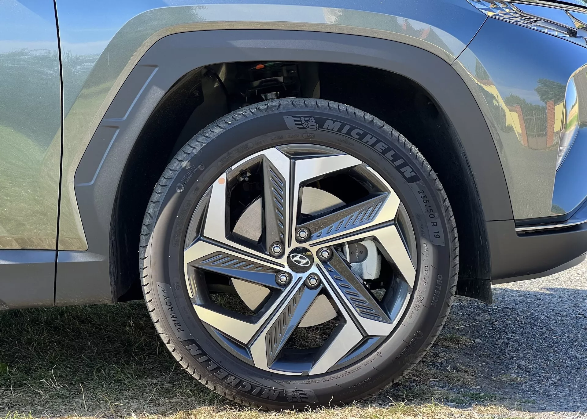 Vista cercana de la rueda delantera y parte del guardabarros del Hyundai Tucson 2020, mostrando un neumático Michelin y un diseño de llanta de aleación dinámica de múltiples radios, destacando la estética automotriz moderna y la marca