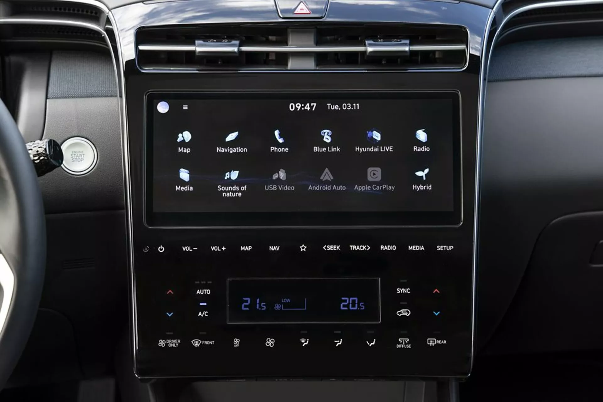 Interior de Hyundai Tucson 2020 con sistema de infoentretenimiento moderno con pantalla táctil, Android Auto y Apple CarPlay, control climático automático de dos zonas establecido a 21 grados Celsius e indicadores de vehículo híbrido