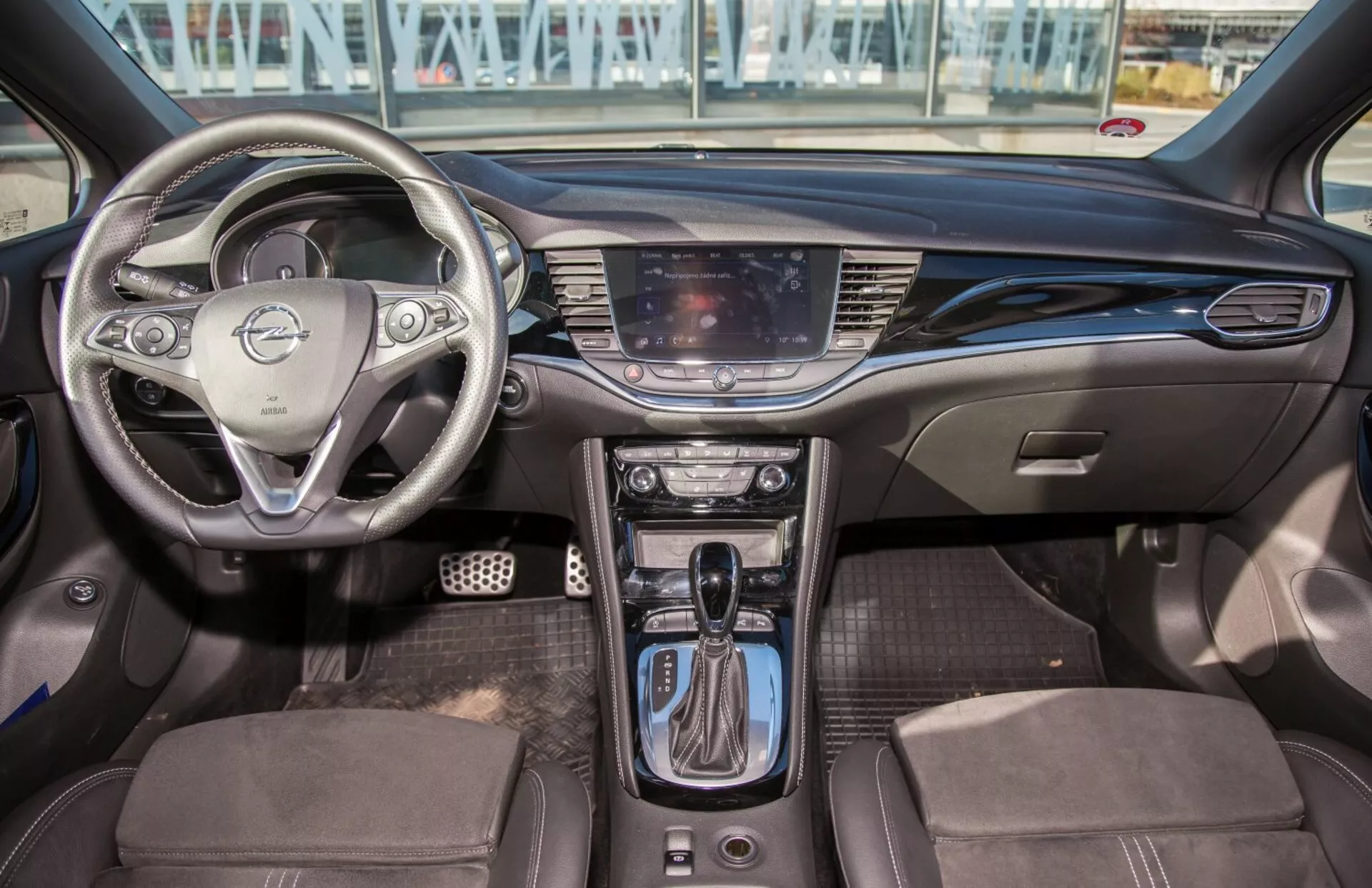 Interior de Kia Ceed 2009 que muestra volante multifunción, sistema de infoentretenimiento táctil, controles de clima de zona dual, cambio de marchas automático, asientos tapizados en dos tonos y diseño moderno de la cabina con comodidades tecnológicas