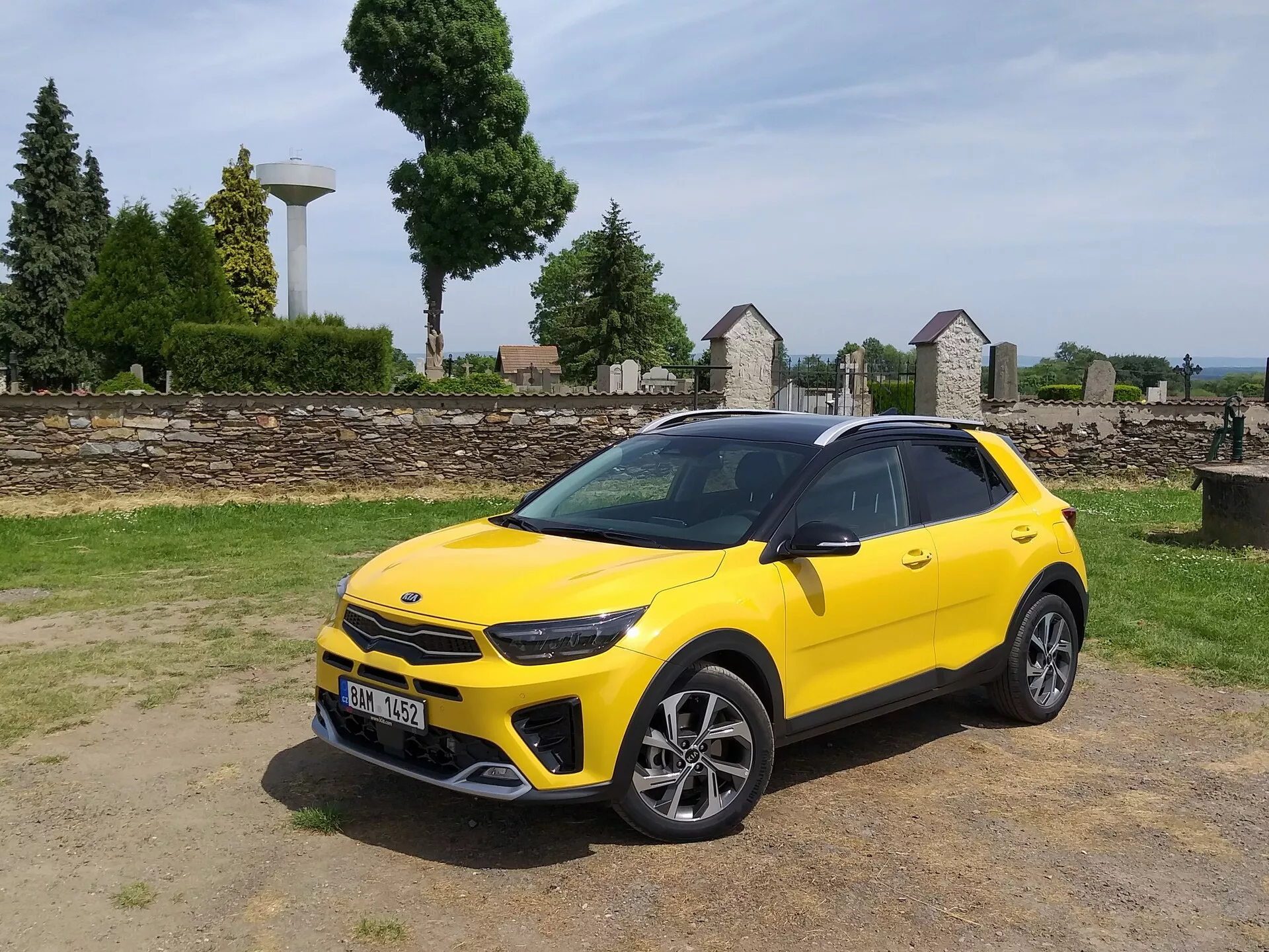 Kia Stonic 2017 en color amarillo brillante, mostrando su parrilla frontal, faros LED, parachoques delantero deportivo y perfil lateral elegante con llantas de aleación de múltiples radios y barras de techo, destacando la estética de crossover compacto y las características de diseño avanzadas del vehículo.