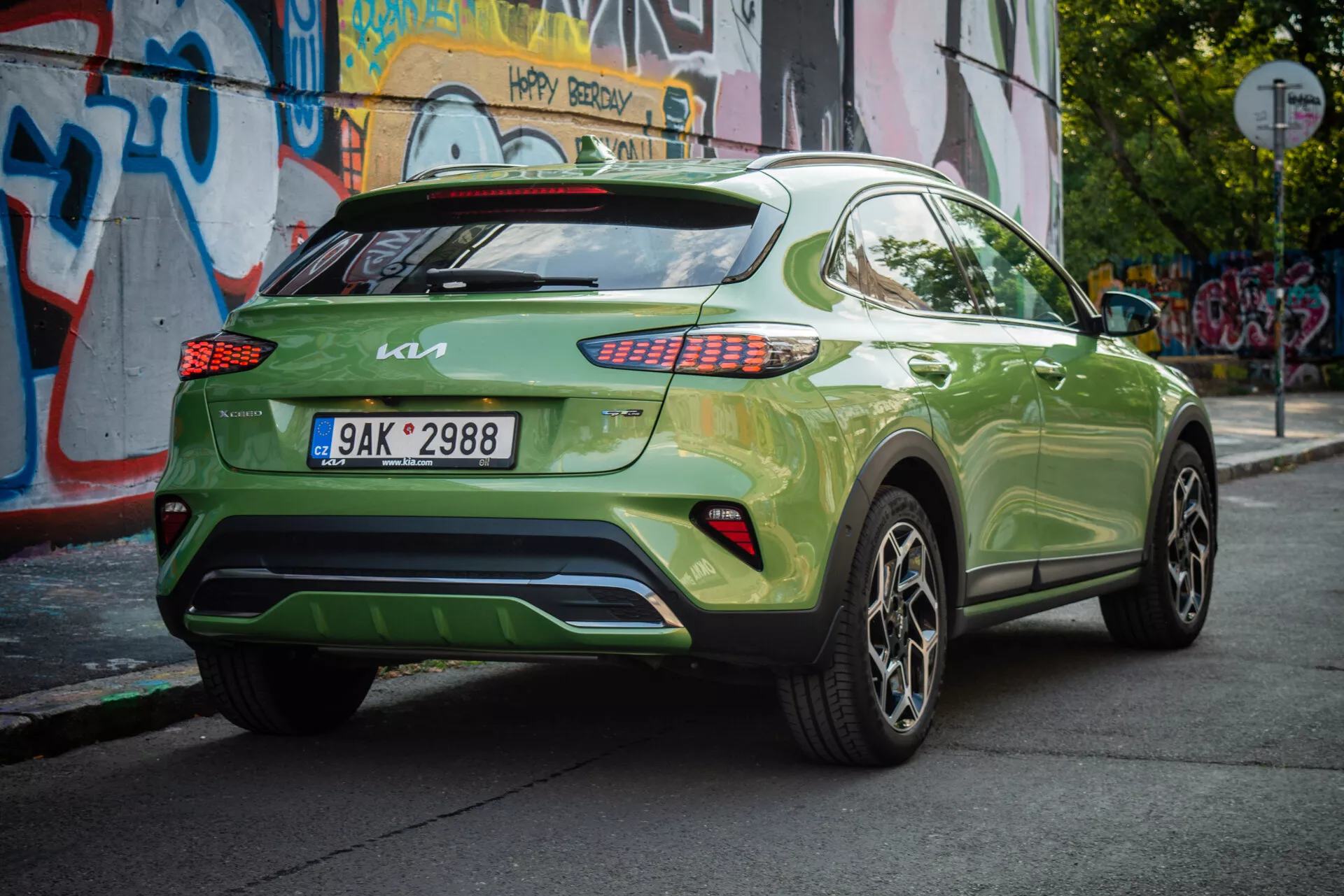 Kia XCeed 2022 en un vibrante verde, mostrando su ángulo trasero de tres cuartos con placa europea, luces traseras LED, ruedas de aleación y un fondo urbano.