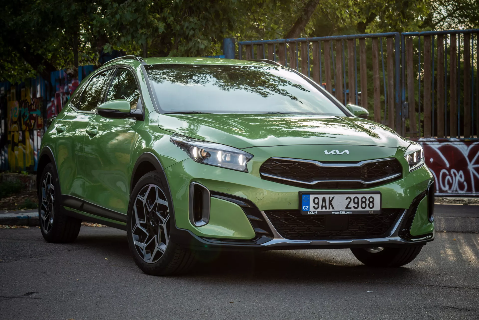Kia Xceed 2022 verde aparcado en ángulo, mostrando su vista frontal de tres cuartos con faros LED y ruedas de aleación deportivas en un entorno urbano