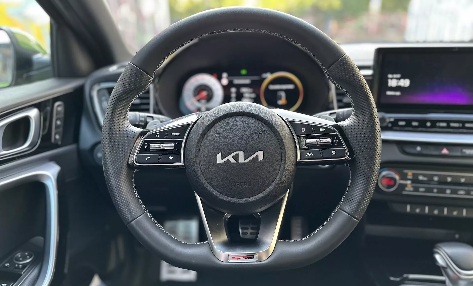 Vista desde la perspectiva del conductor dentro de un Kia Xceed 2022 que muestra el tablero de mandos, volante con botones de control, cuadro de instrumentos digital-analógico y consola central multimedia