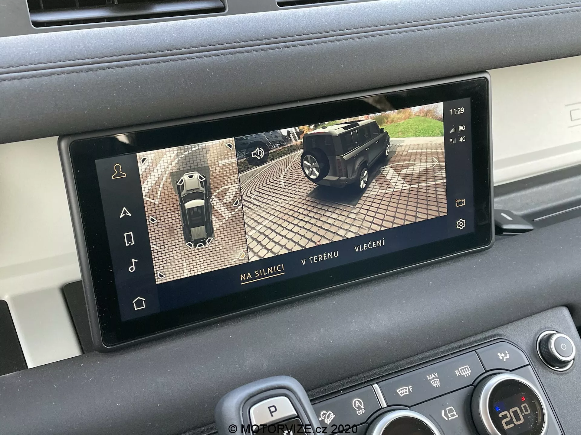 Pantalla interior del Land Rover Defender 2020 que muestra un sistema de cámara de vista de 360 grados, parte de los sistemas avanzados de asistencia al conductor (ADAS). La pantalla rectangular está integrada en la consola central del vehículo y muestra tres modos de visualización: en carretera, fuera de carretera y nocturno. La pantalla ayuda con el estacionamiento y la maniobra al combinar imágenes de varias cámaras alrededor del automóvil.