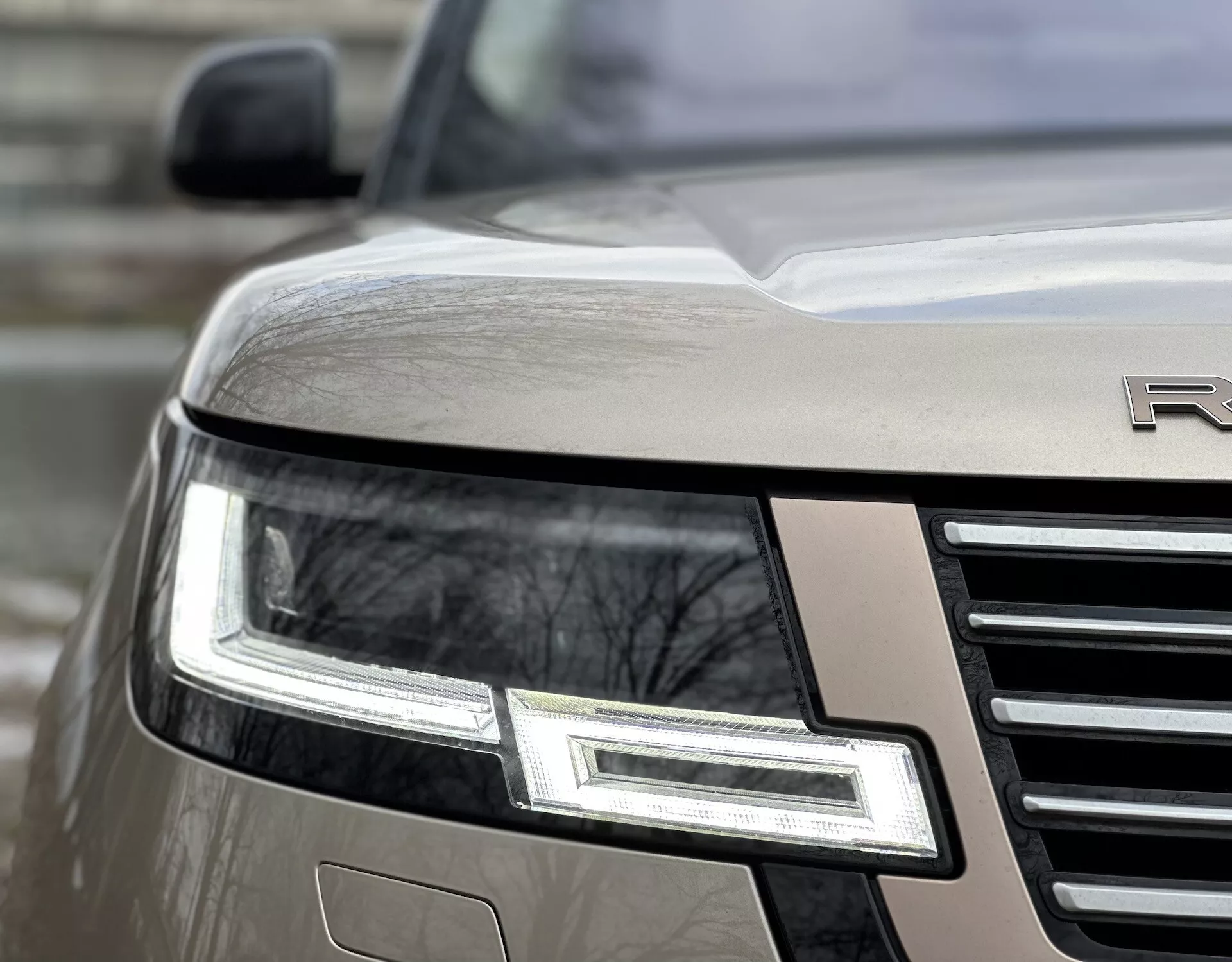 Vista en ángulo cercano de la esquina frontal del Land Rover Range Rover 2021 destacando el conjunto de faros LED, parrilla cromada y emblema parcial en un cuerpo metálico