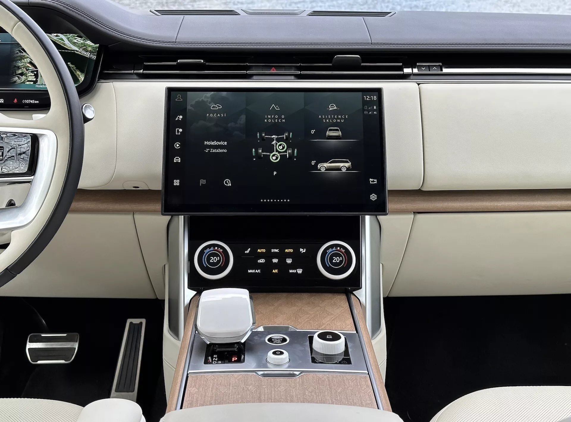 Land Rover Range Rover 2021 con interior moderno, centrado en la consola central y el sistema de infoentretenimiento con pantalla táctil de alta resolución, rejillas de aire con detalles en cromo, control climático de zona dual, dial de control rotativo para navegación del sistema y asientos de lujo en cuero de dos tonos con detalles de acabado en madera.