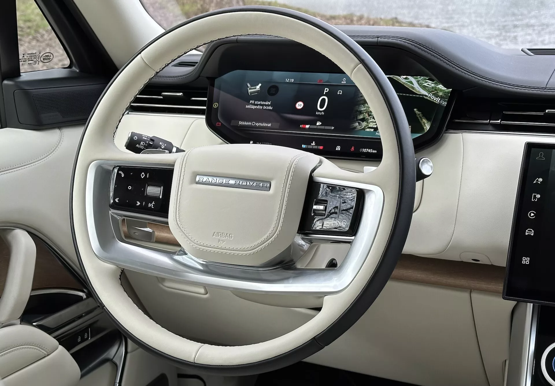 Vista interior del Land Rover Range Rover 2021 que muestra los controles del volante y el tablero digital del conductor con acabado cromado y de lujo