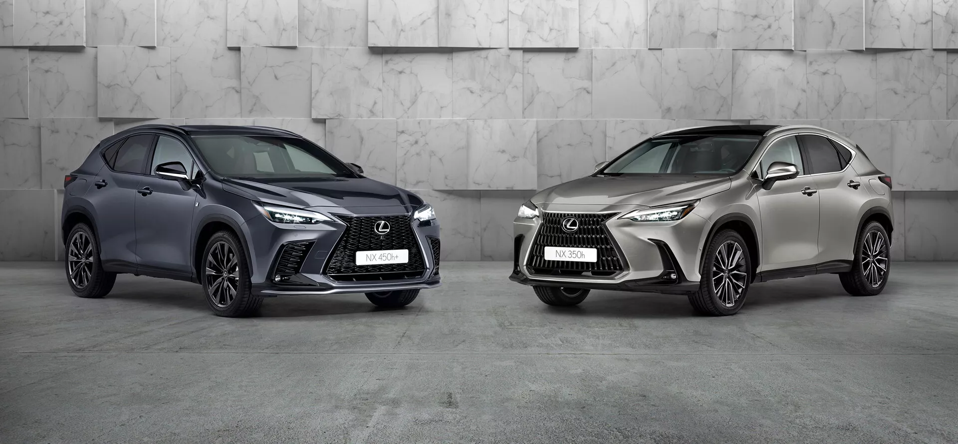 La imagen muestra dos coches Lexus NX 2021 en un entorno de estudio profesional. El coche de la izquierda, un SUV compacto de color oscuro con una rejilla frontal agresiva distintiva, faros LED afilados y grandes tomas de aire, está orientado para mostrar su frente izquierdo y el lado. Las ruedas están giradas hacia la cámara, destacando el diseño de las llantas. El coche de la derecha, en un color metálico claro, también está inclinado pero hacia la izquierda, compartiendo un lenguaje de diseño similar con un estilo de llanta diferente. Ambos SUVs de lujo, posicionados prominentemente en el marco, exhiben un diseño avanzado y posibles tecnologías modernas.