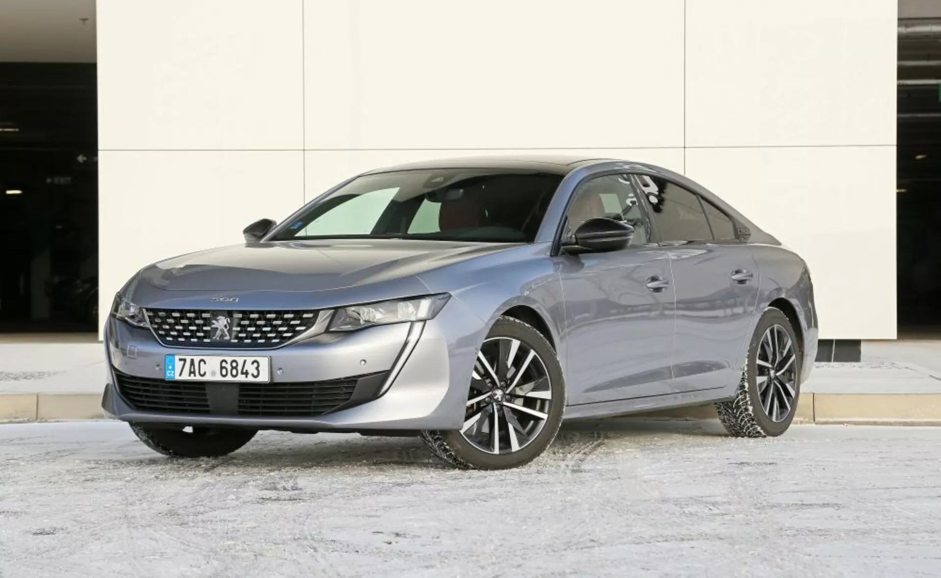 Sedán Mazda 6 del 2013 estacionado al aire libre con una ligera capa de nieve, mostrando un diseño elegante y características modernas como faros LED y detalles cromados