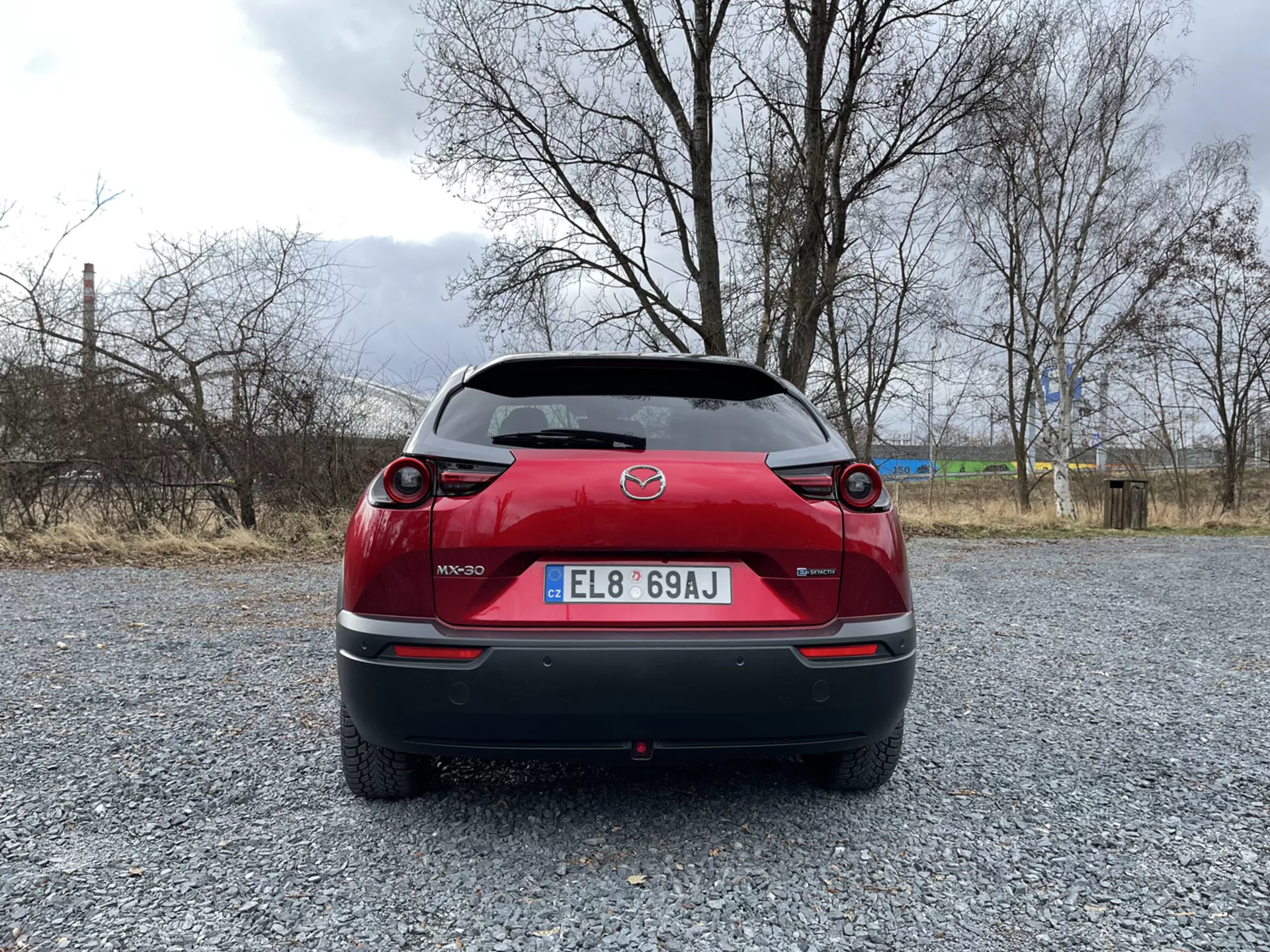 Mazda MX-30 del 2020 en un elegante color metálico mostrando su diseño moderno y tecnología eléctrica, aparcado en una ubicación pintoresca